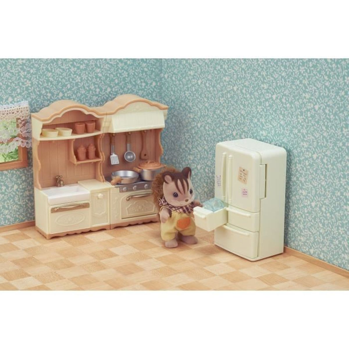 Una ardilla de juguete está junto a un juego de cocina y un refrigerador de juguete.