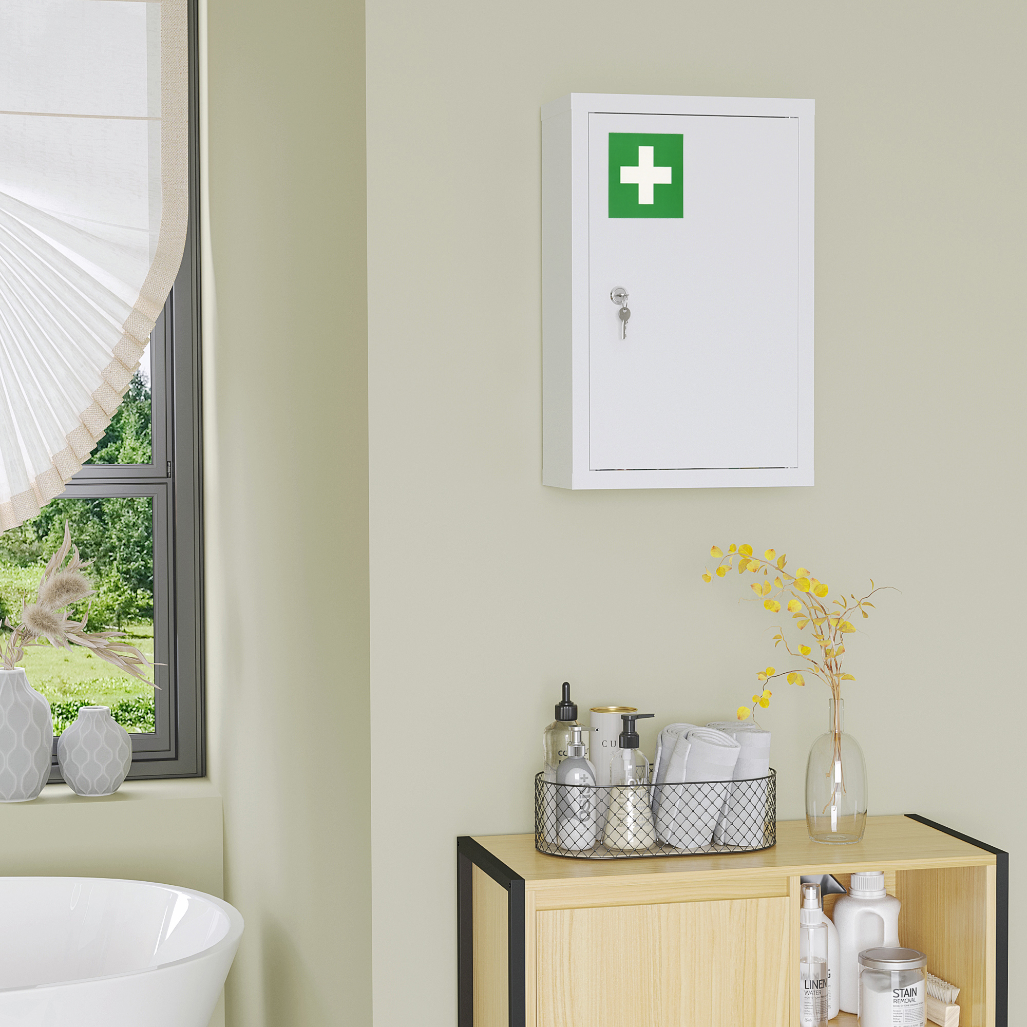 Un botiquín blanco con cruz verde cuelga en pared verde claro sobre mueble de madera.