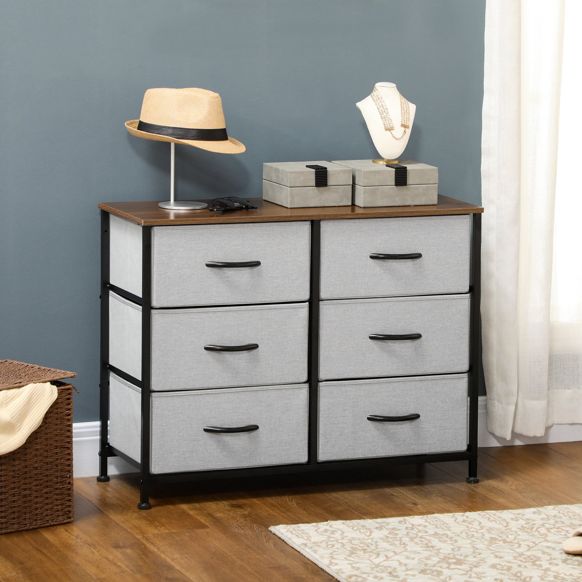 Cómoda de marco de metal negro con 6 cajones grises, tapa de madera, sombrero y joyas.