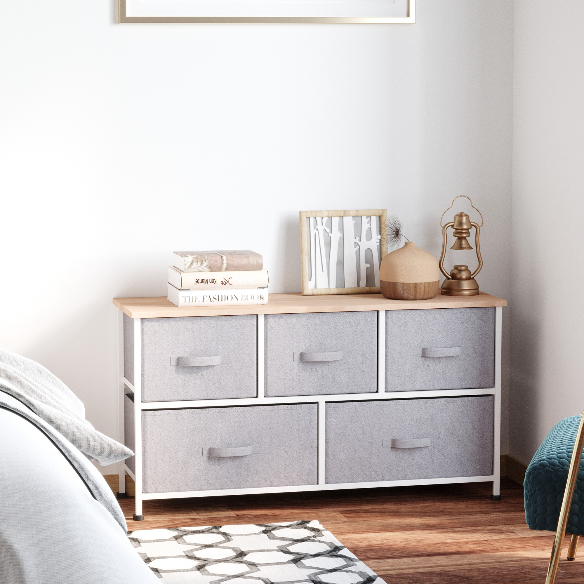 Cómoda con seis cajones grises junto a una cama. Decoraciones adornan la parte superior.