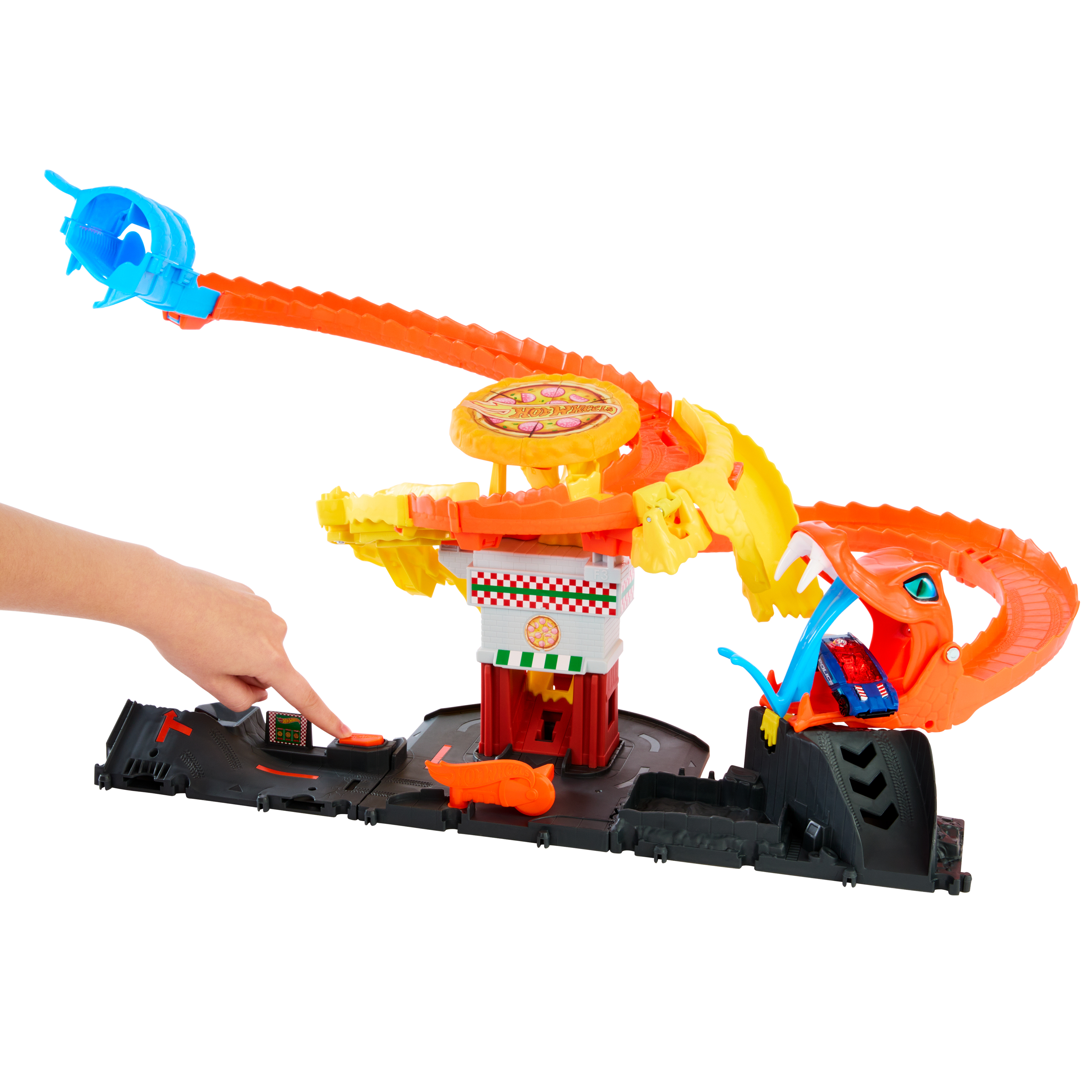 Un niño presiona un botón en un set de coches de juguete Hot Wheels con torre de pizza y pista de serpiente.