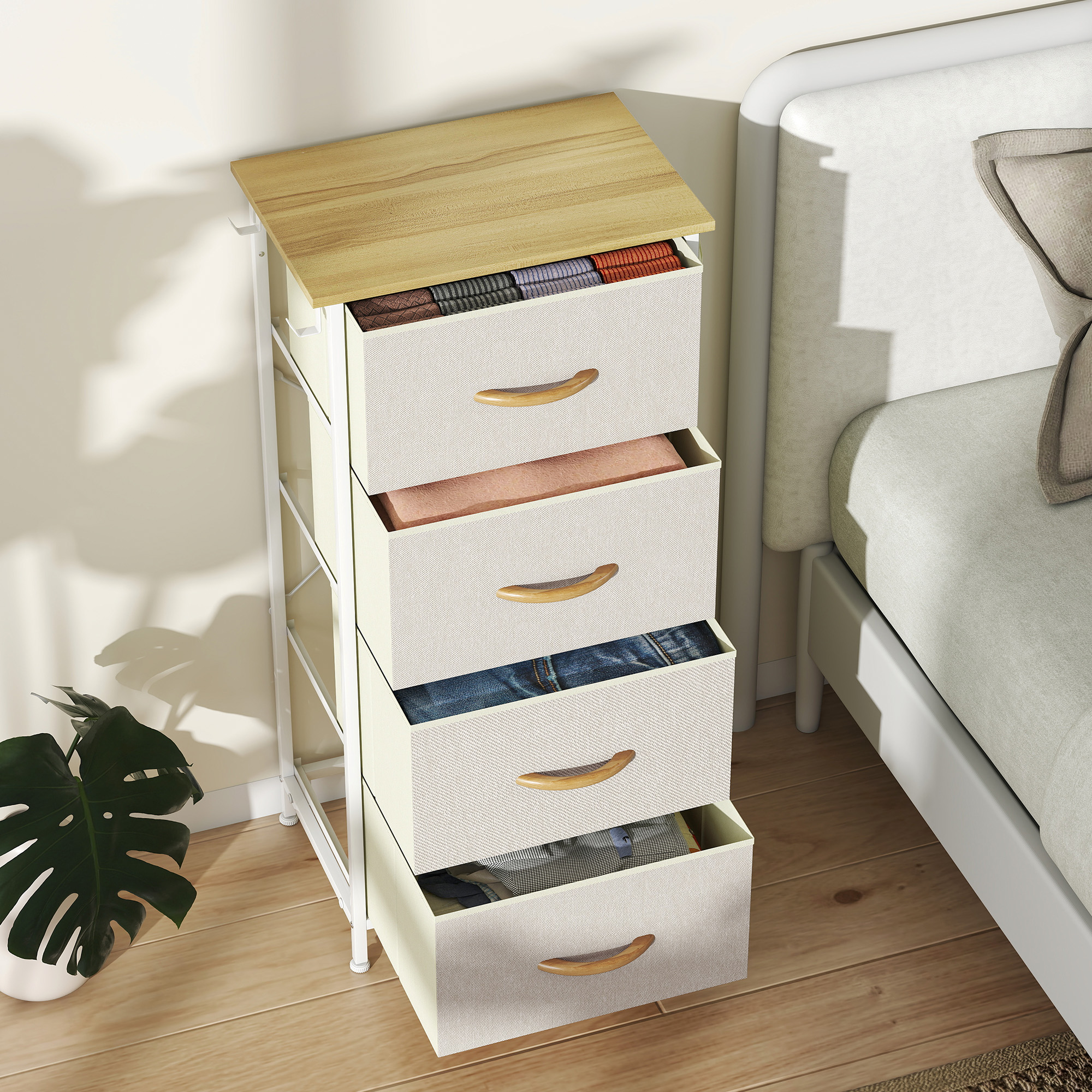 Un tocador blanco estrecho con tapa de madera, junto a una cama. Ropa en cajones.