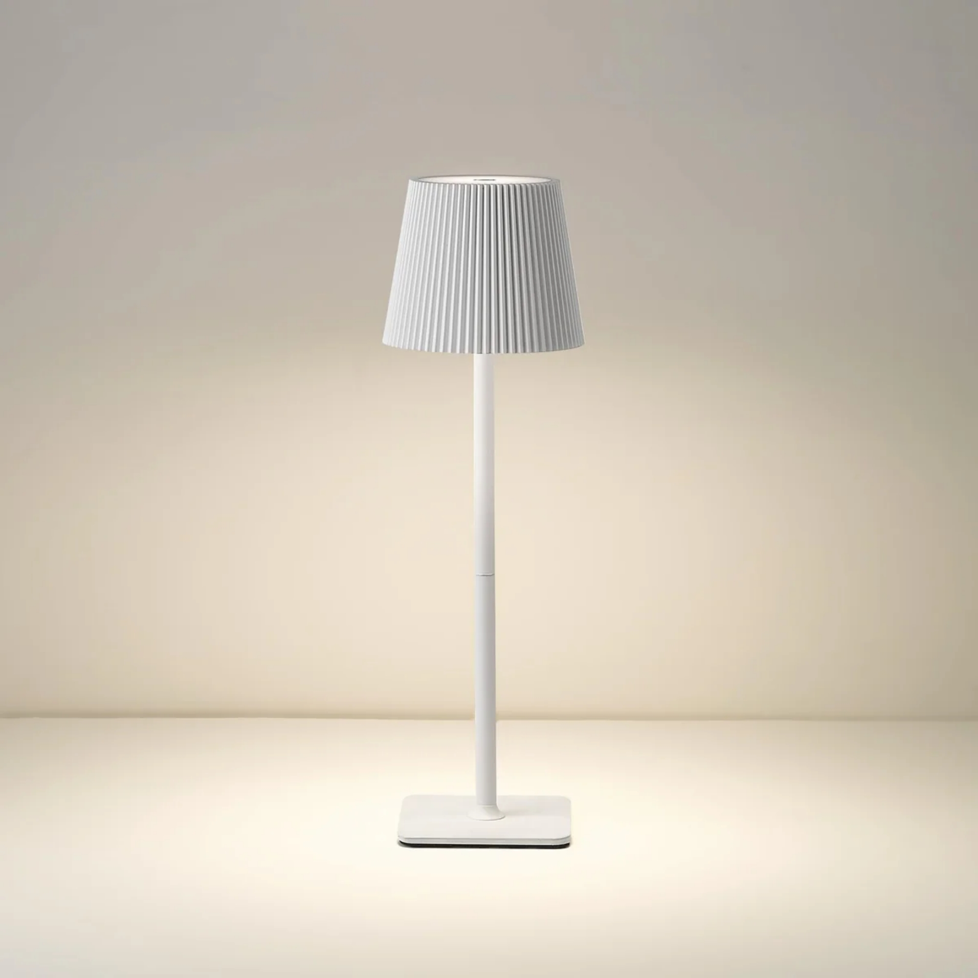 Eine weiße Stehlampe mit geripptem Lampenschirm steht auf einem rechteckigen Sockel.