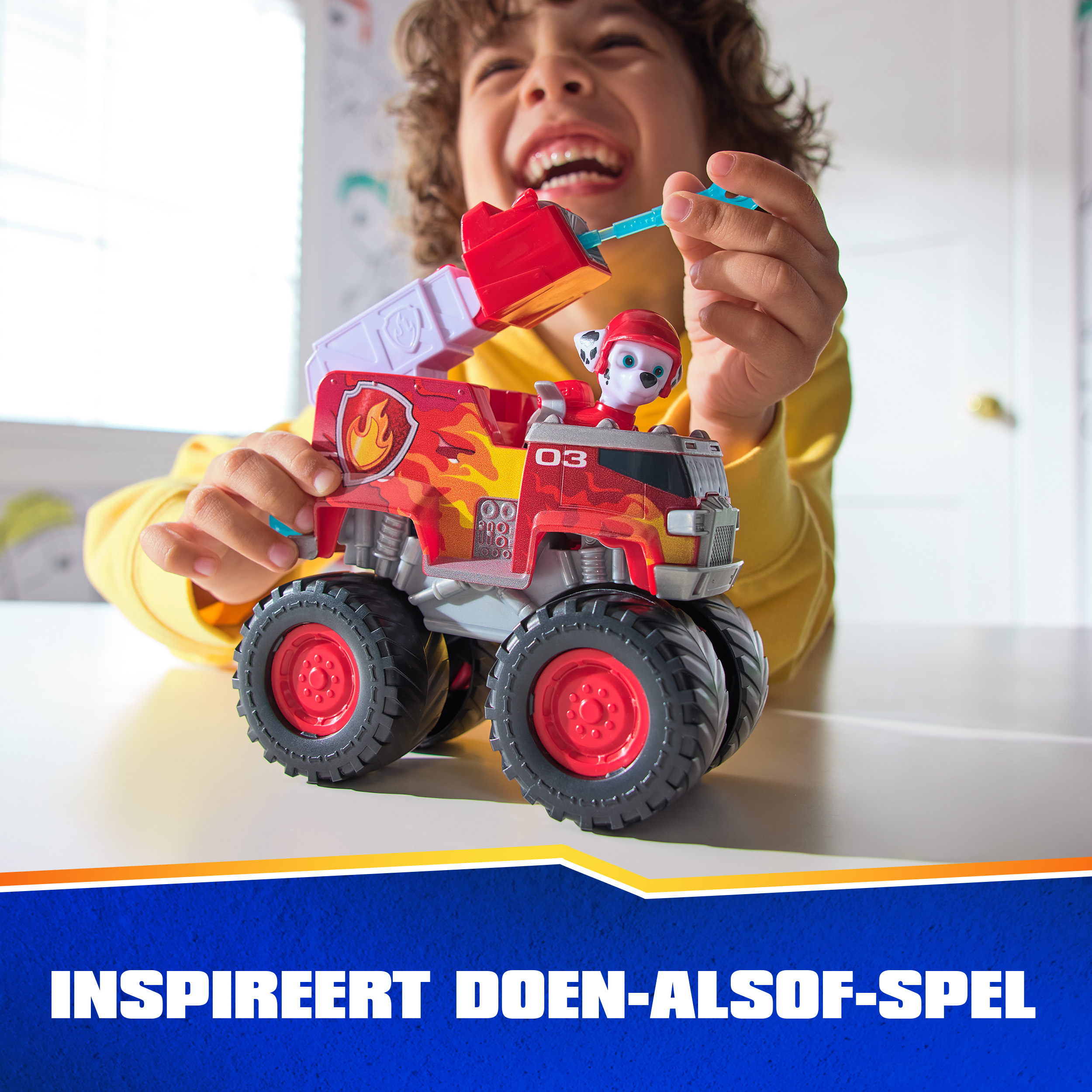 Un niño juega con un camión de bomberos de juguete rojo con Marshall de Paw Patrol.