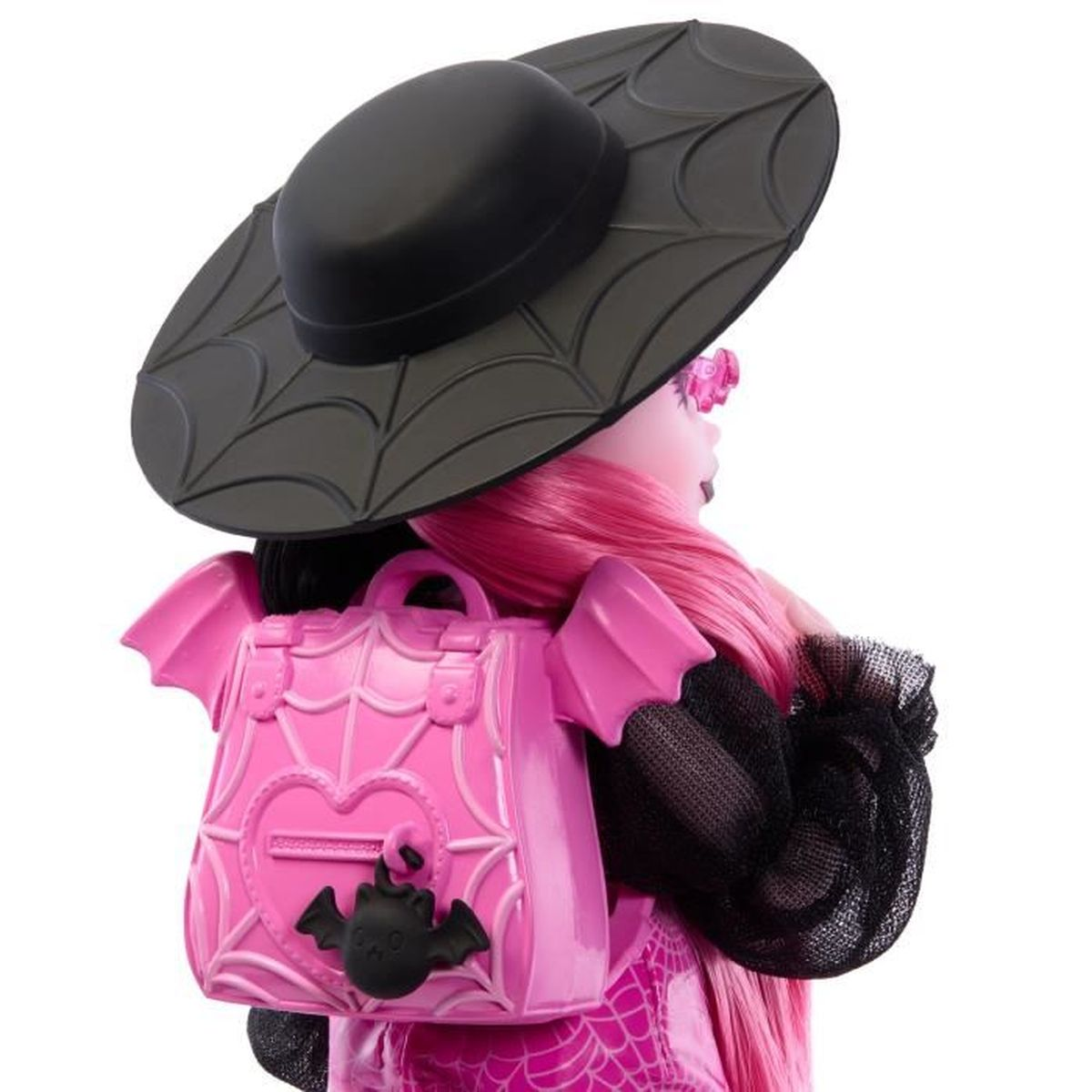 Una muñeca de pelo rosa lleva un sombrero negro con telaraña y una mochila rosa con amuleto de murciélago.