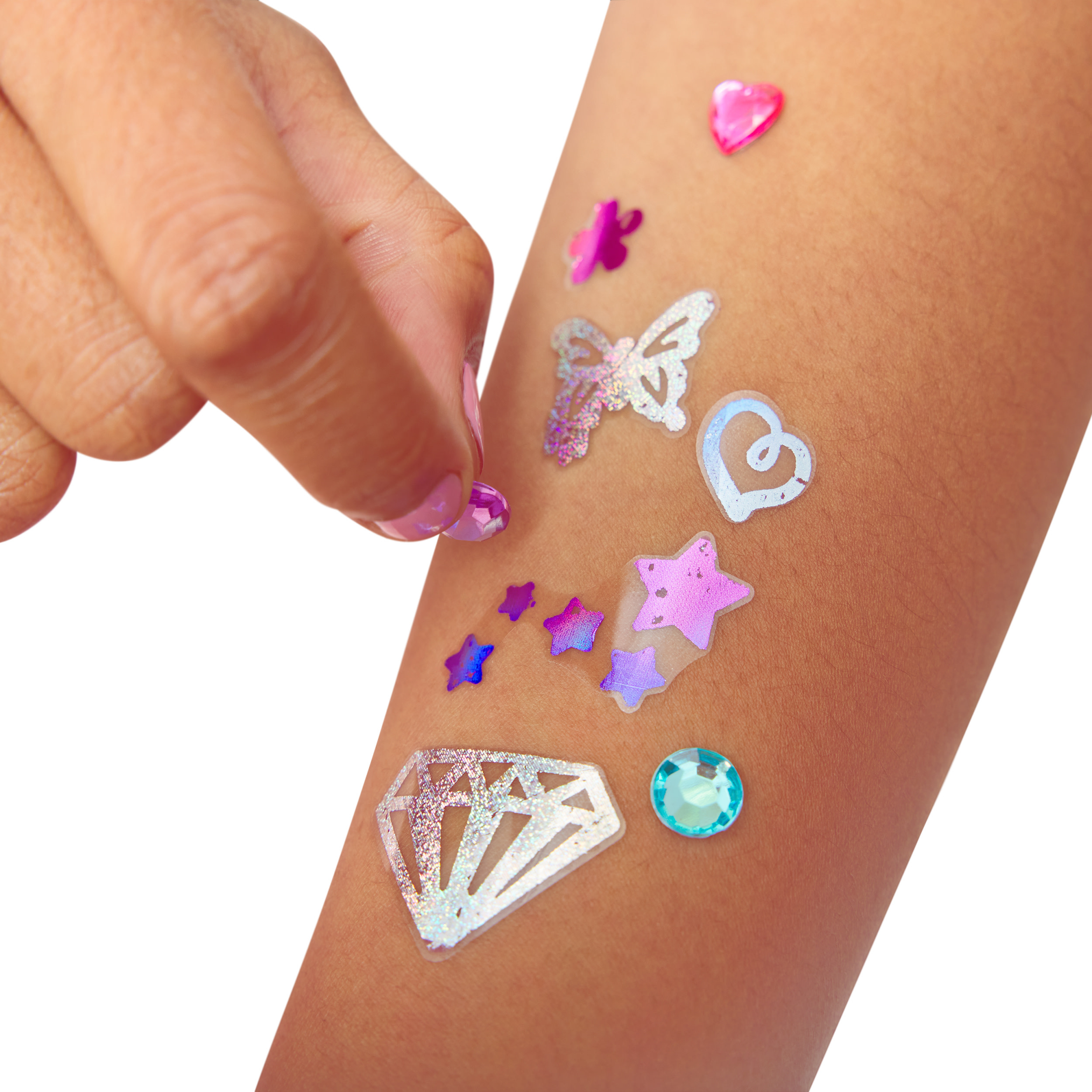 Un dedo con esmalte aplica un adhesivo brillante en un brazo.