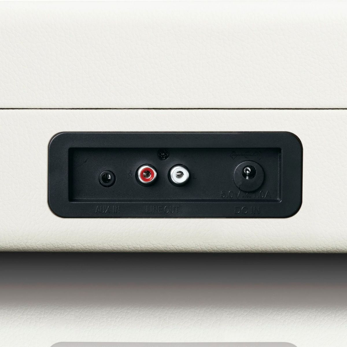 Aux in, line out and DC in ports on a white device.
