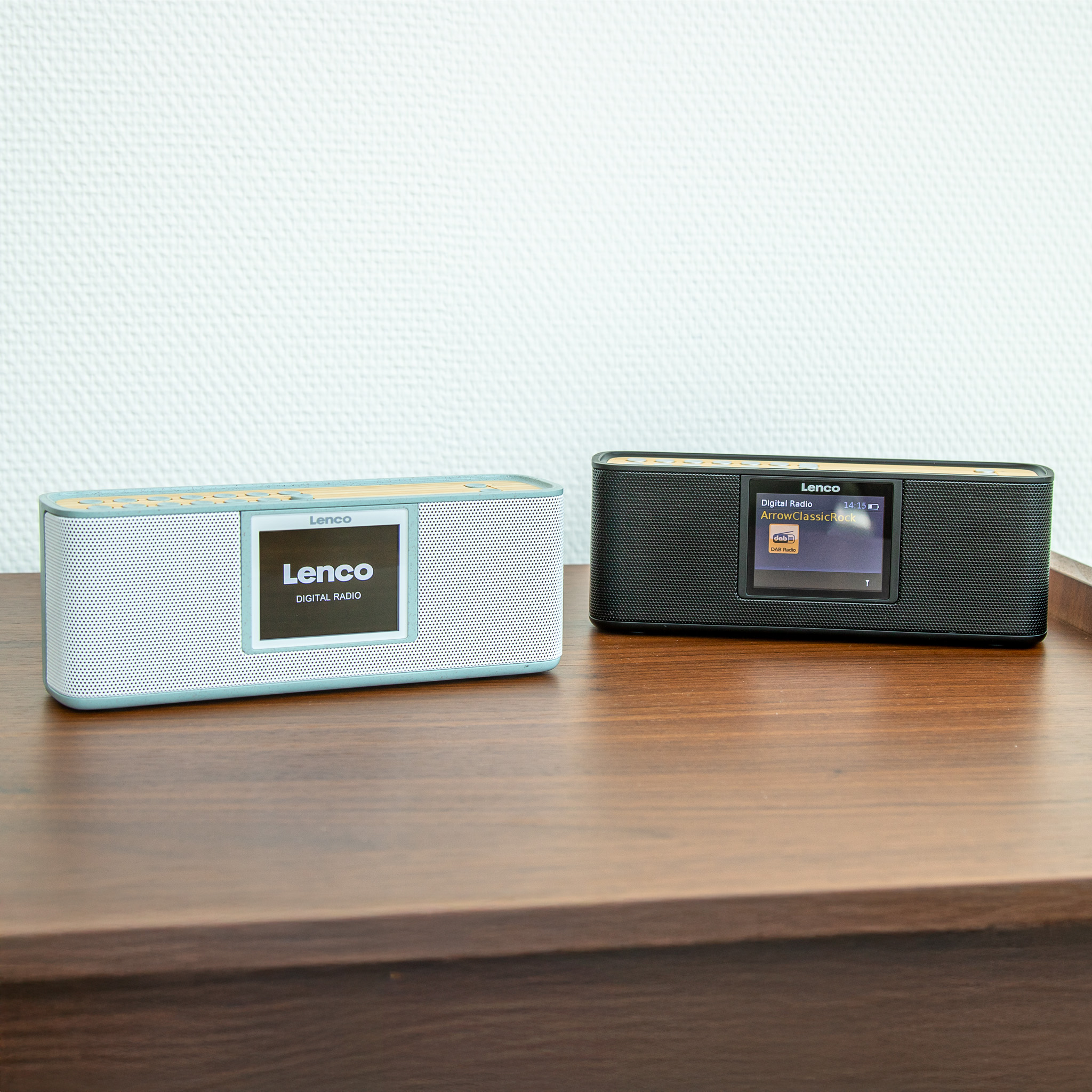 Zwei Lenco Radios stehen auf einem Holztisch. Eines ist hellblau, das andere schwarz.