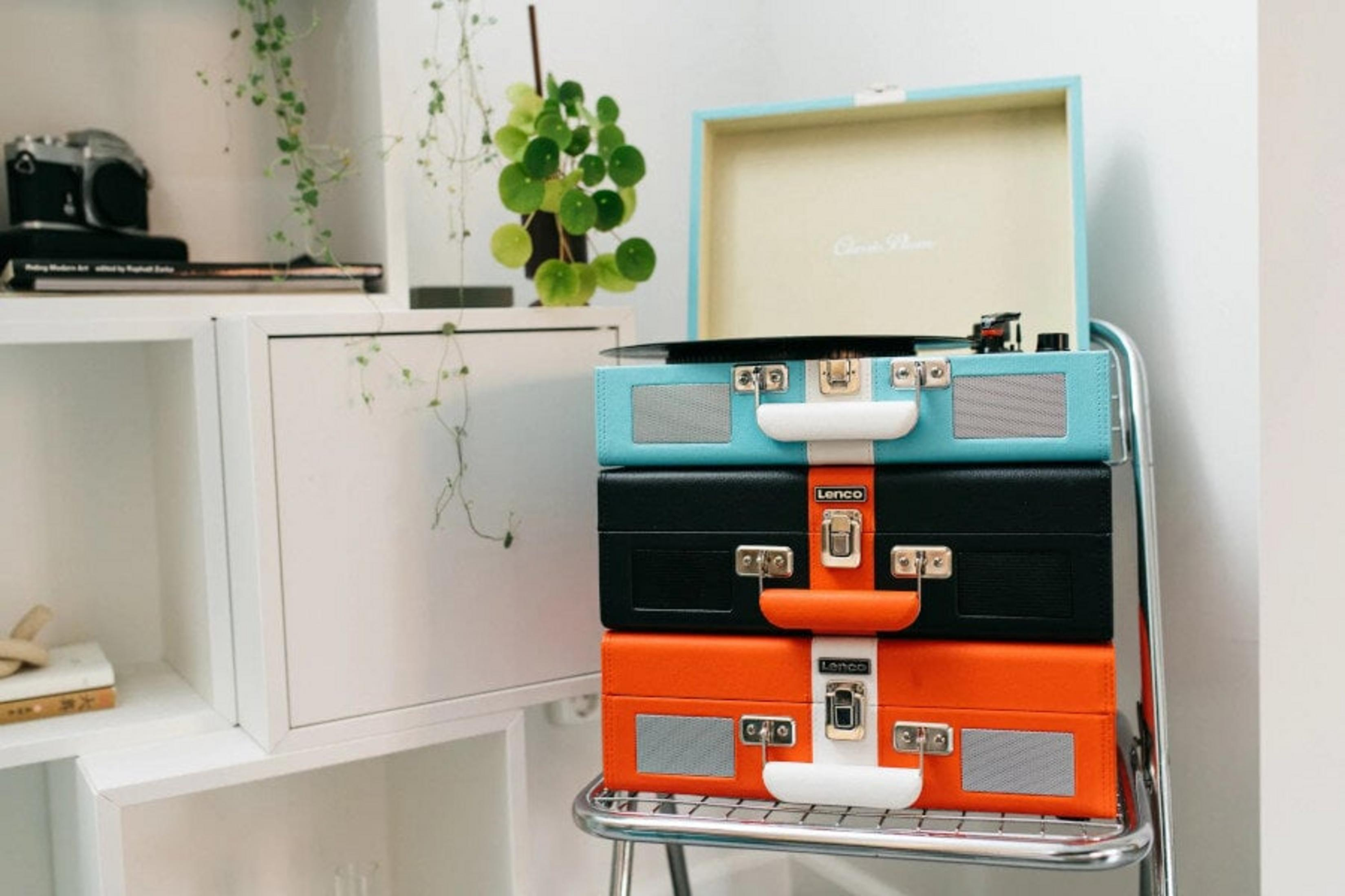 Trzy ułożone na sobie gramofony: niebieski, czarny i pomarańczowy, na srebrnej półce.