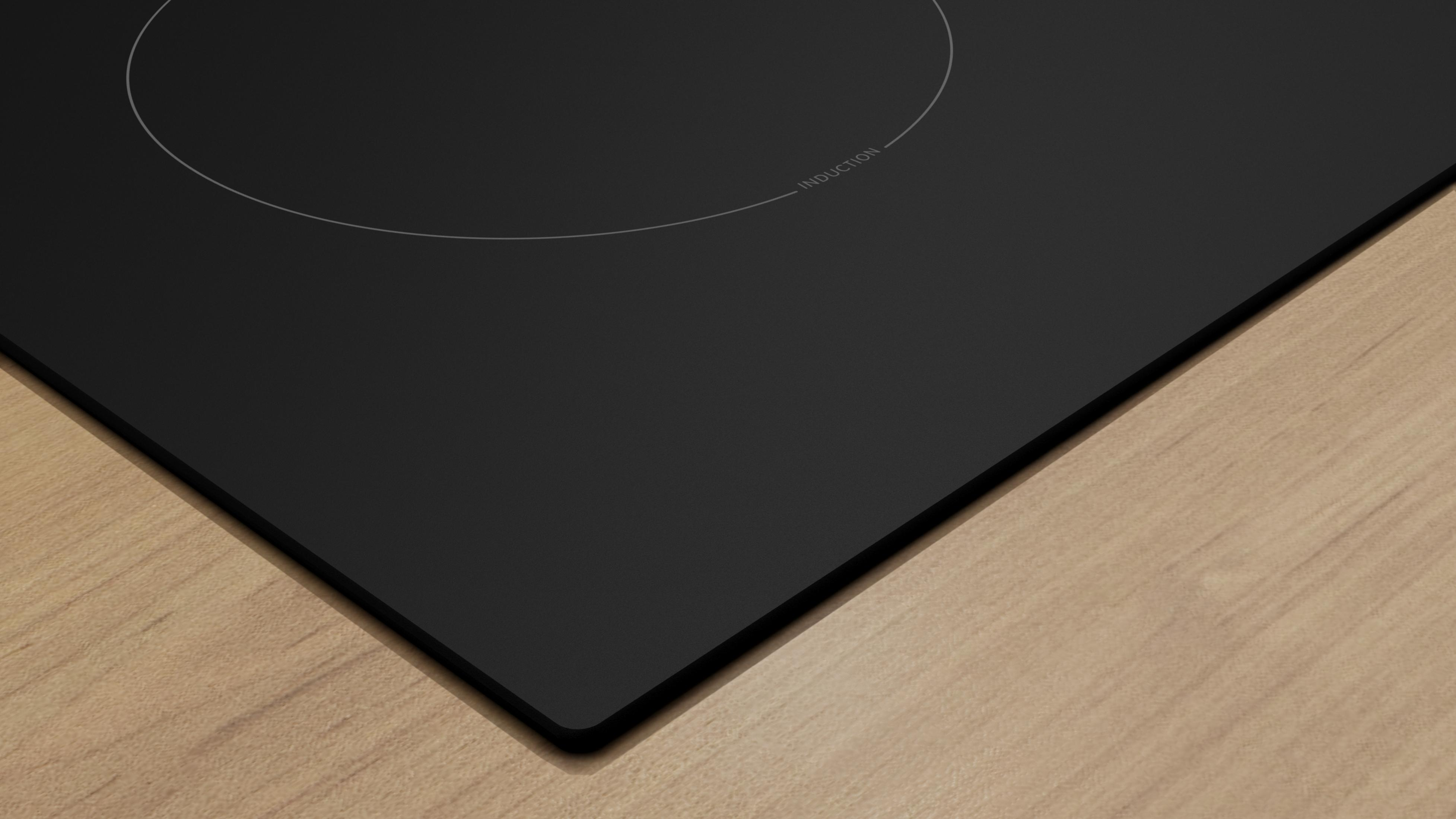Czarna płyta indukcyjna na drewnianej powierzchni.