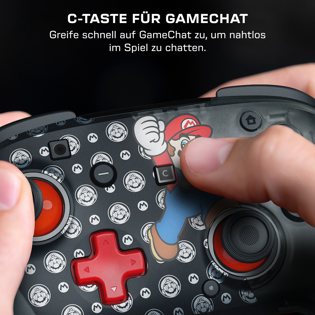 Eine Hand drückt die C-Taste auf einem schwarzen Gamecontroller mit Mario-Grafik.