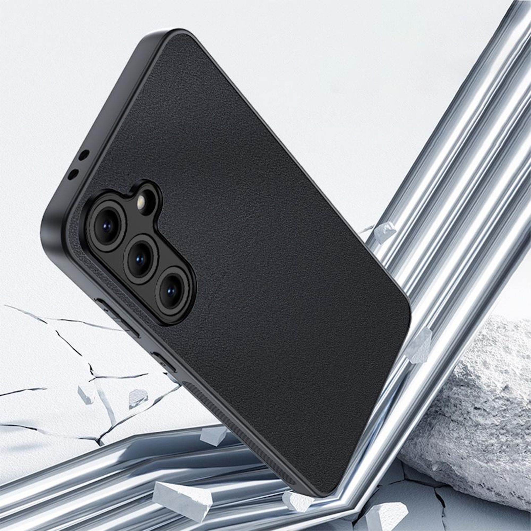 Funda de teléfono negra con elemento de cámara sobre superficie rota.