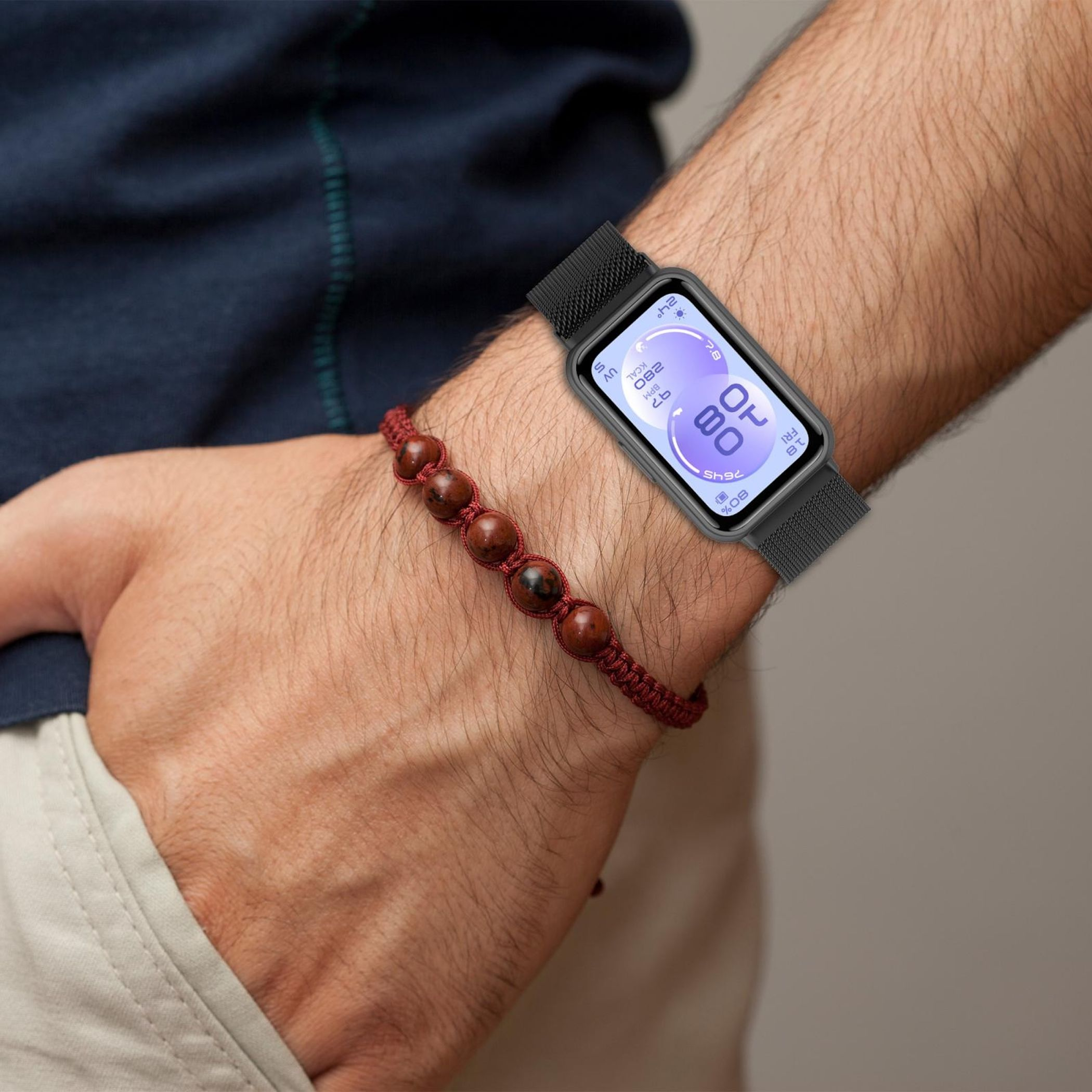 Eine Hand trägt ein schwarzes Smartwatch-Armband und ein rotes Perlenarmband. Die Uhr zeigt 80 %.