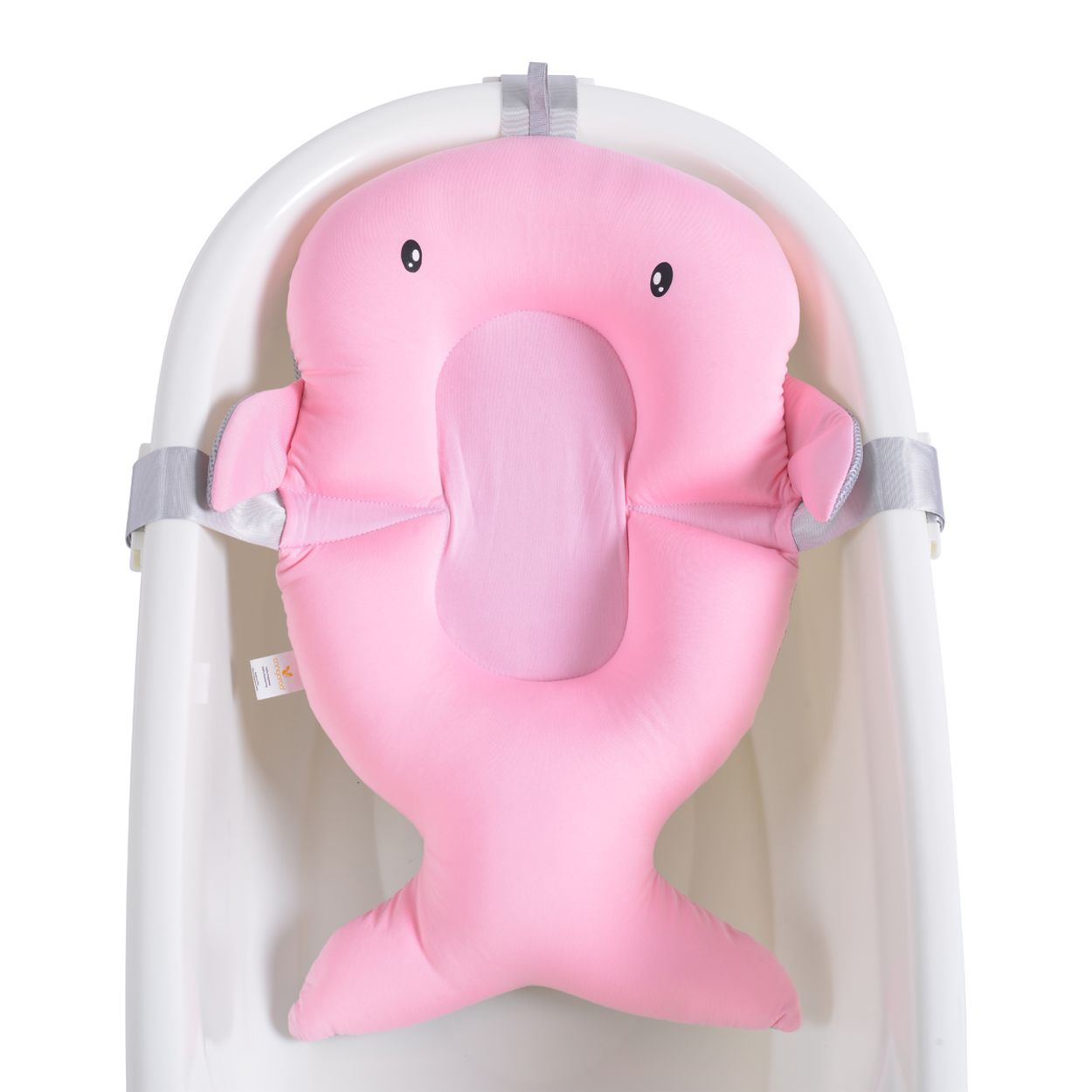 Ein rosa baby-badkissen in walform mit schwarzen augen sitzt in einer weißen badewanne.