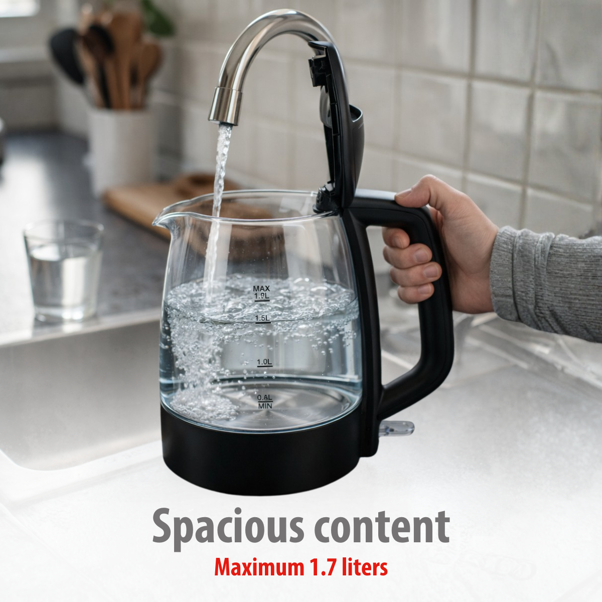Wasser fließt aus einem Wasserhahn in einen durchsichtigen Wasserkocher, der fast voll ist.