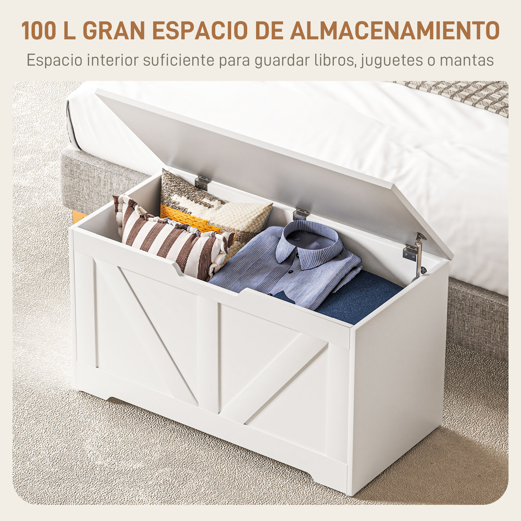 Arcón de almacenamiento blanco con tapa abierta, lleno de cojines y ropa, junto a una cama.