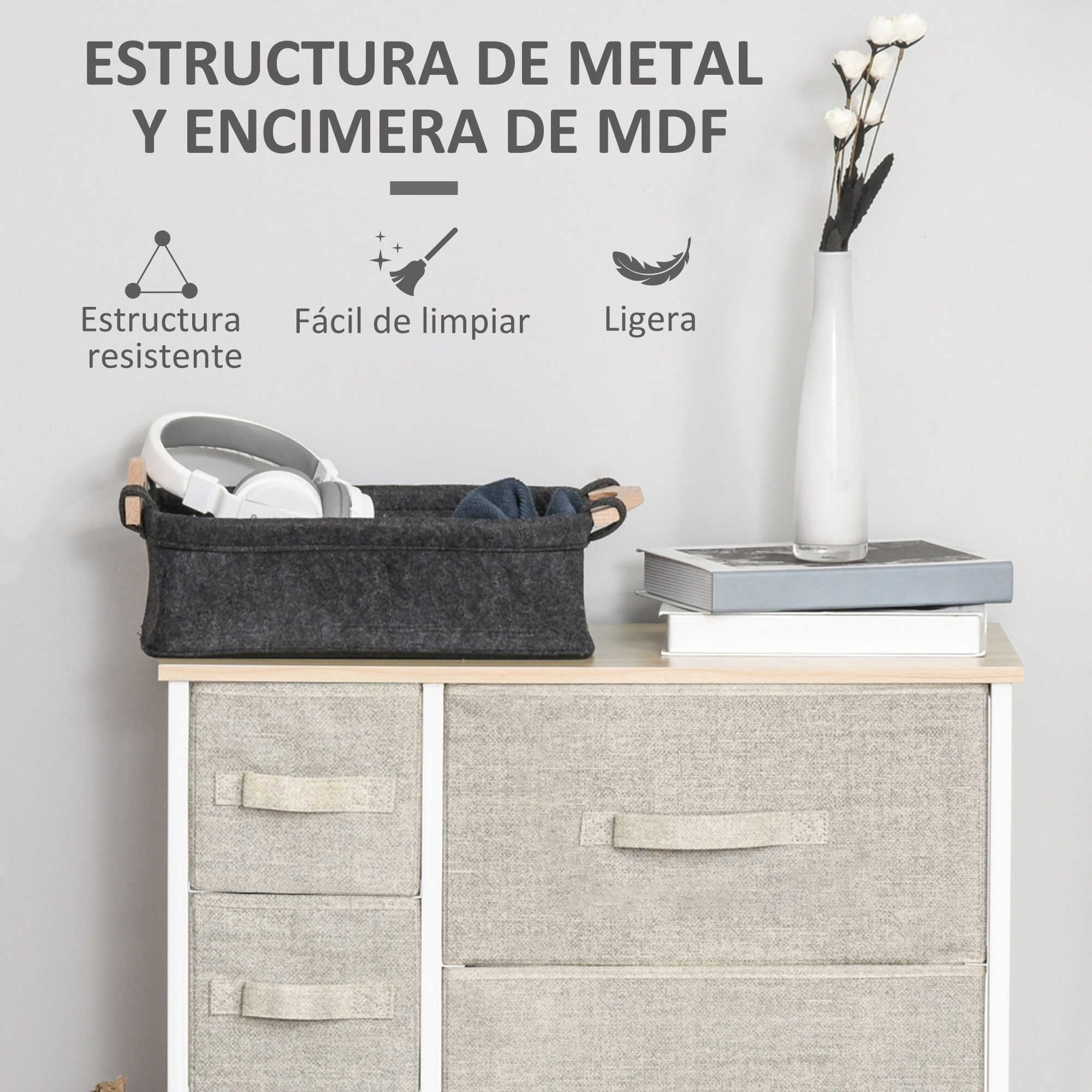 Un cesto de tela con auriculares y libros encima de una unidad de cajones.