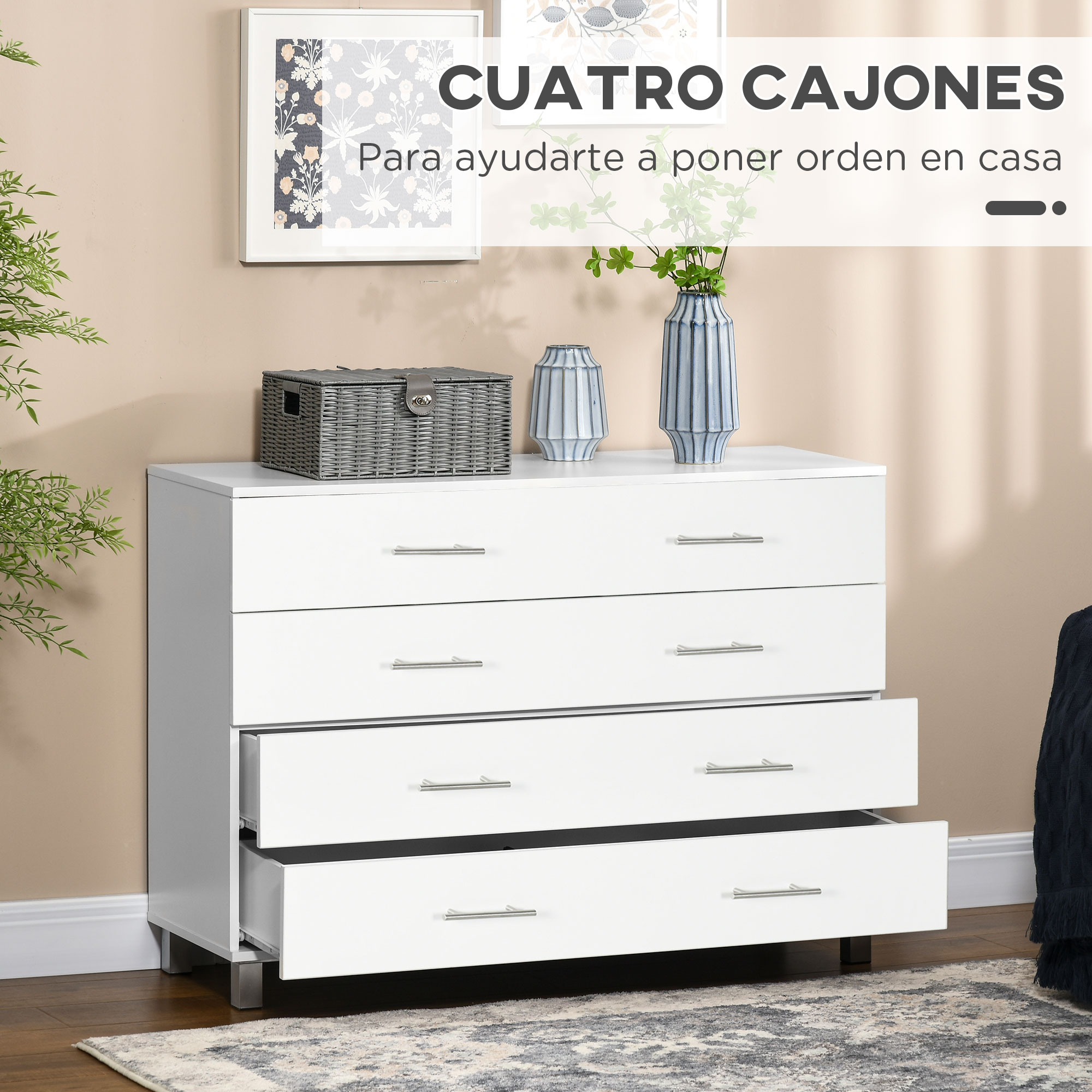 Una cómoda blanca de cuatro cajones con tiradores plateados sobre suelo de madera.