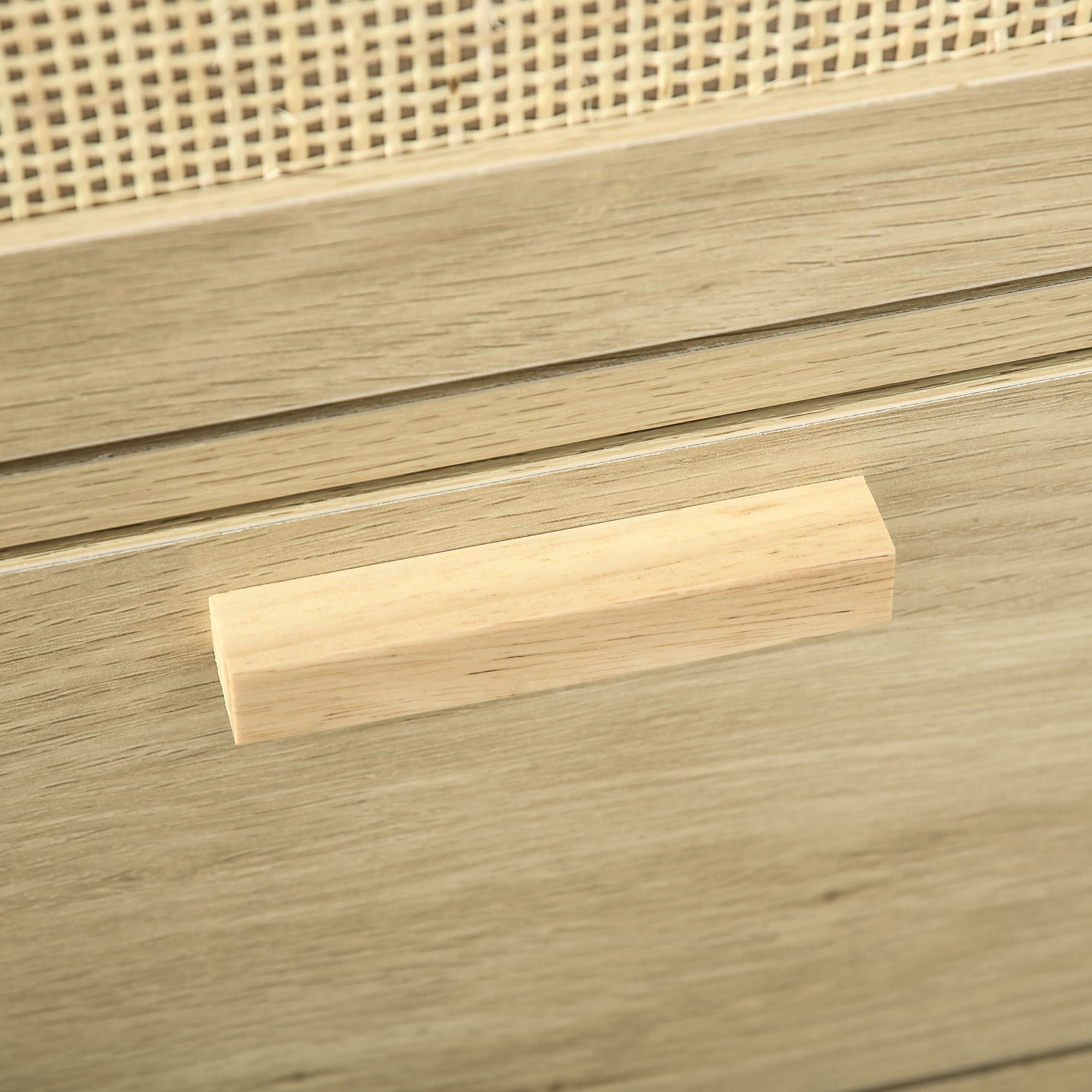 Primer plano de un tirador de mueble de madera sobre fondo de veta de madera.