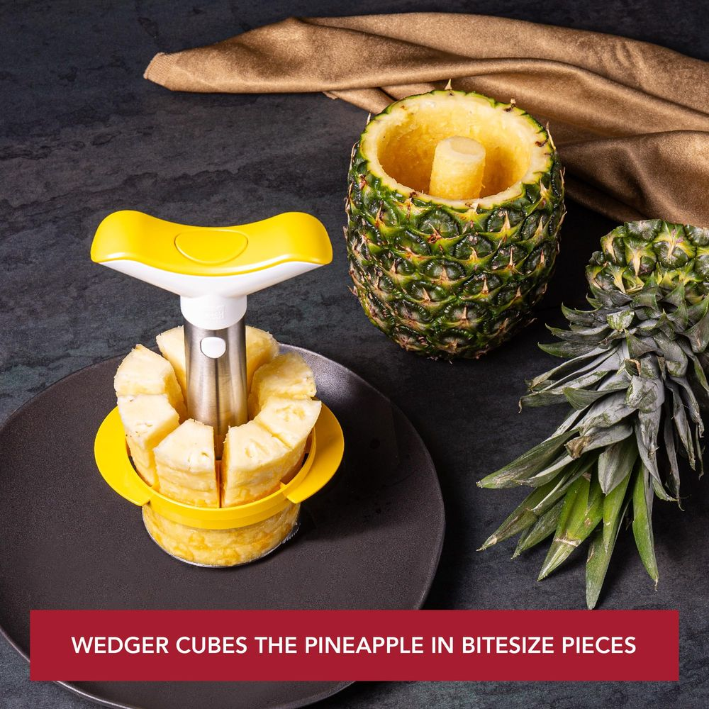Un tagliapineapple giallo su un piatto taglia l'ananas a pezzi.