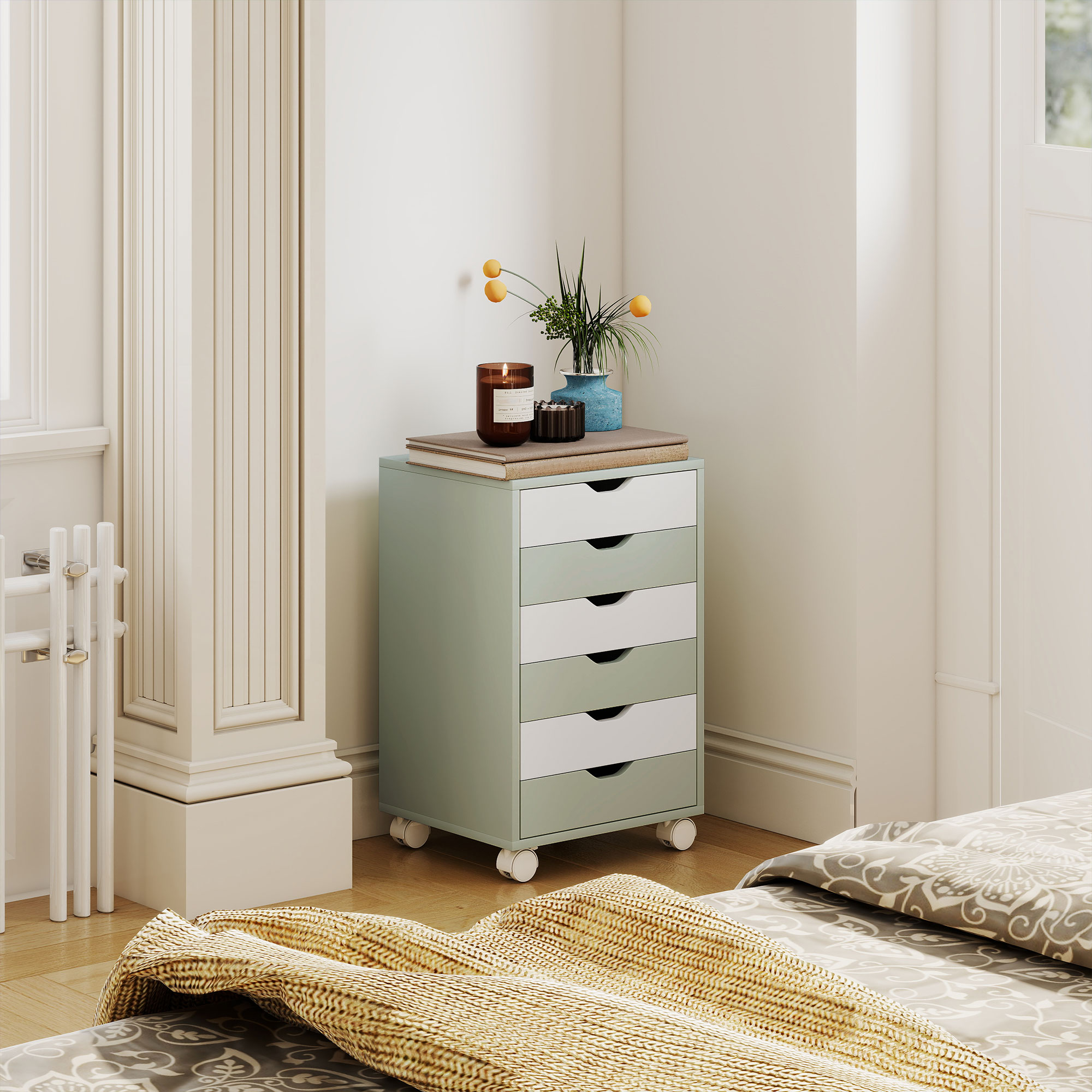 Un mueble con ruedas verde menta junto a una cama con ropa de cama estampada.