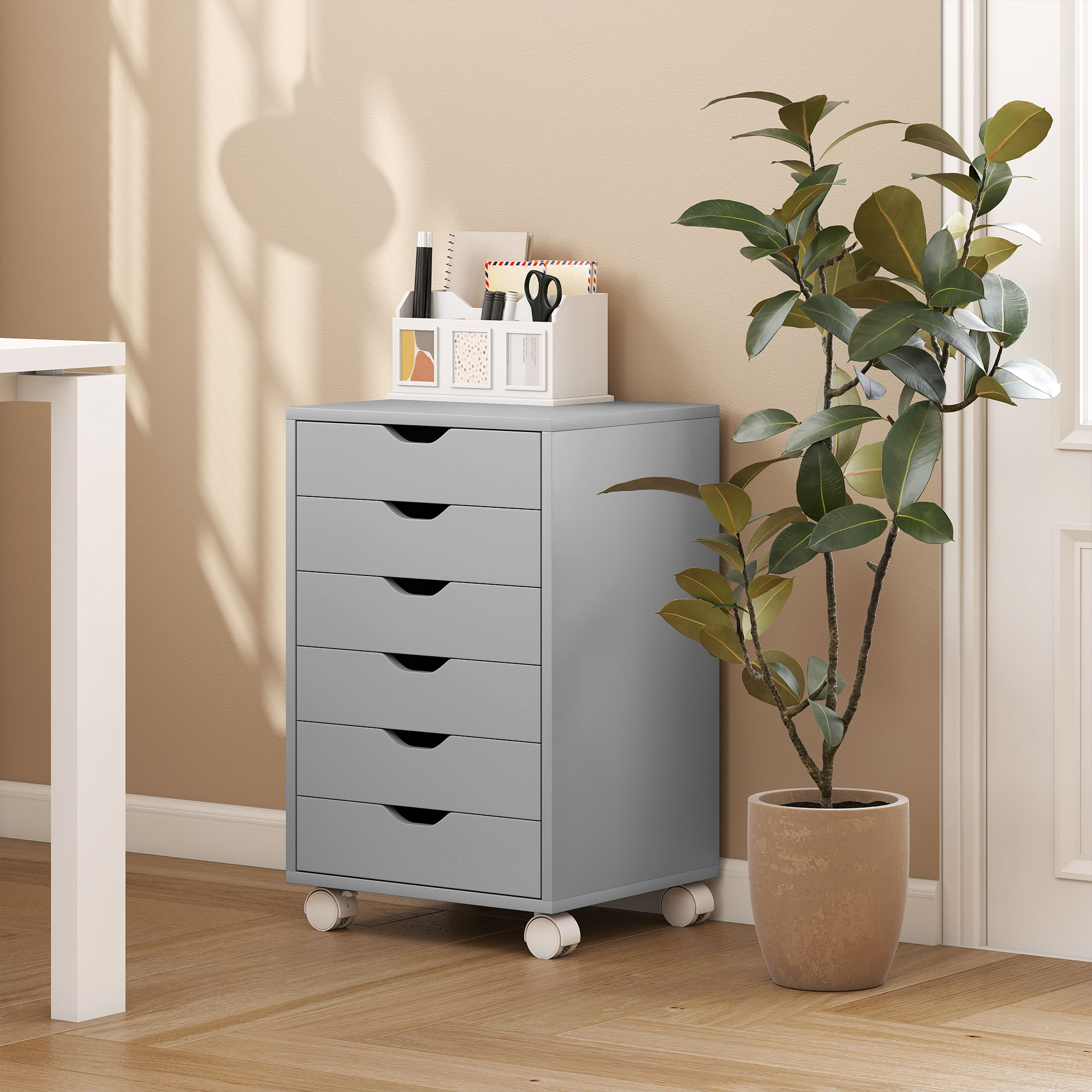 Gabinete gris con ruedas y seis cajones junto a una planta.