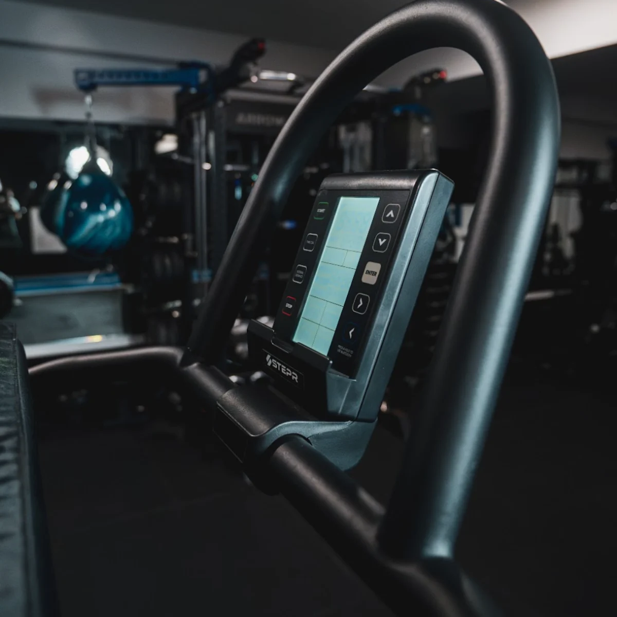 A close-up of a black elliptical machine's console in a gym.
