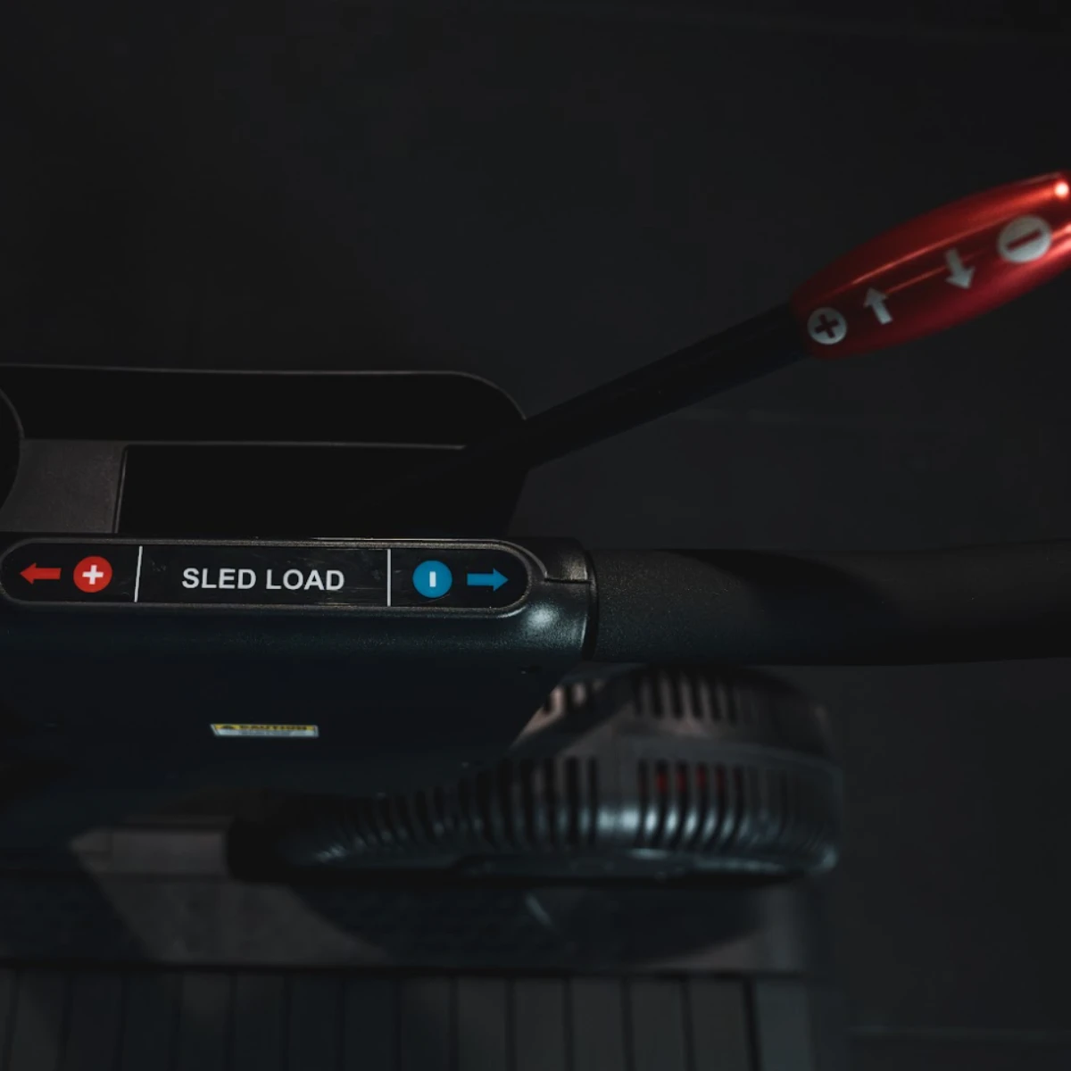 A red handle with plus and minus signs above a black band with 