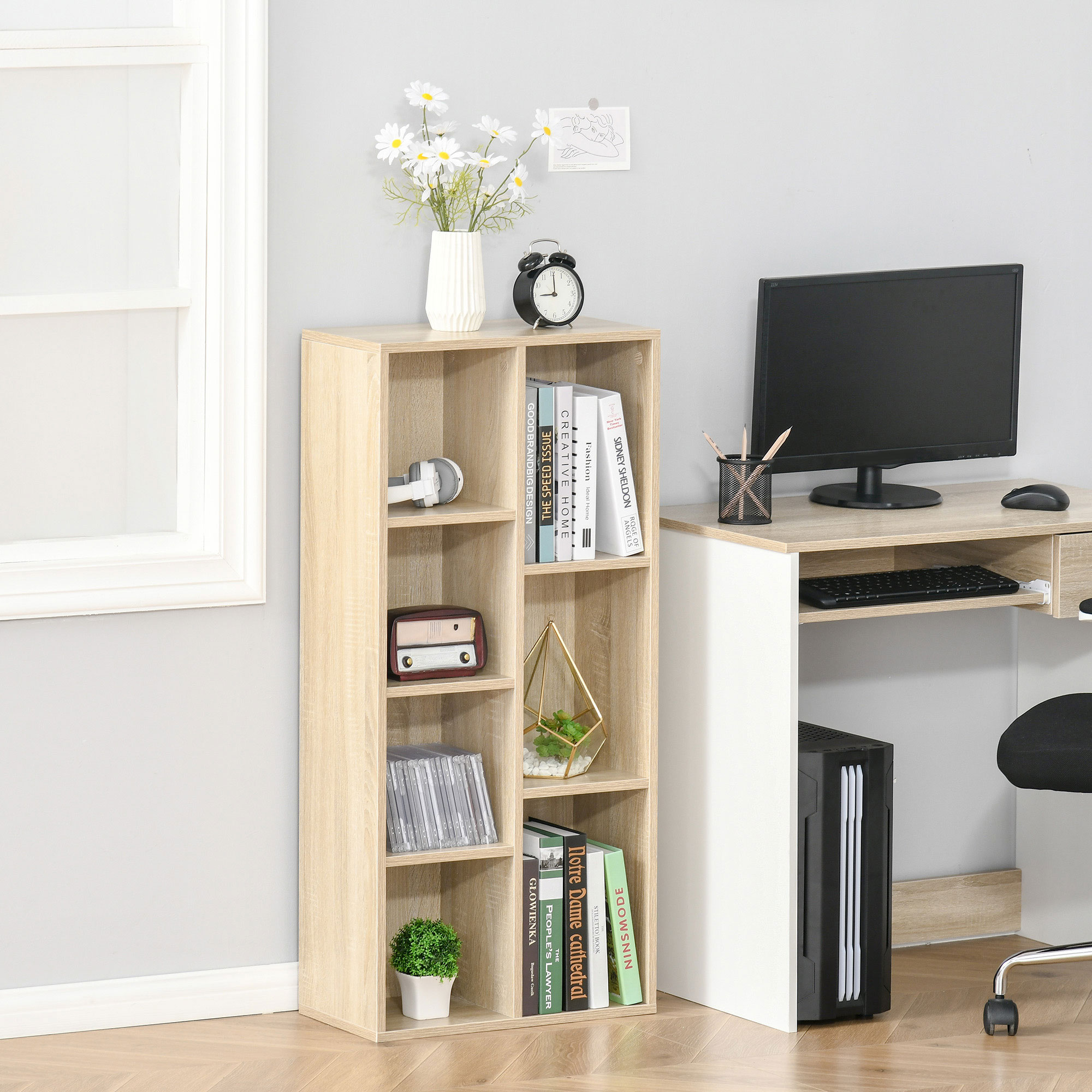 Estantería de madera clara con libros, auriculares, jarrón y despertador.