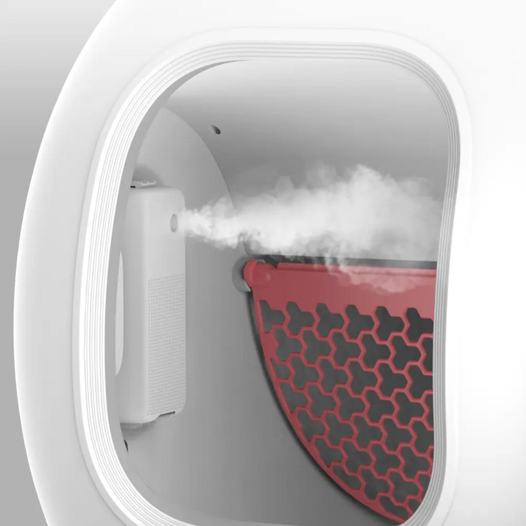 Ein Diffusor sprüht Dampf auf ein rotes Gitter im Inneren eines weißen Geräts.
