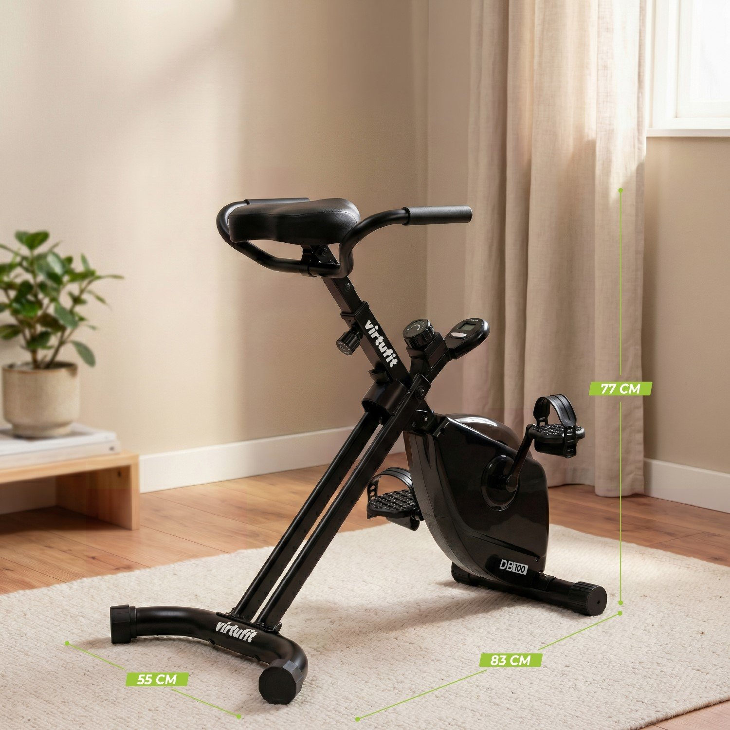 Ein schwarzes Indoor-Fahrrad steht auf einem Teppich. Maße sind angegeben.