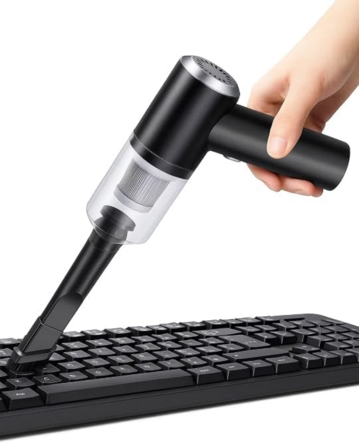 Hand hält schwarzen Mini-Staubsauger über einer schwarzen Tastatur.