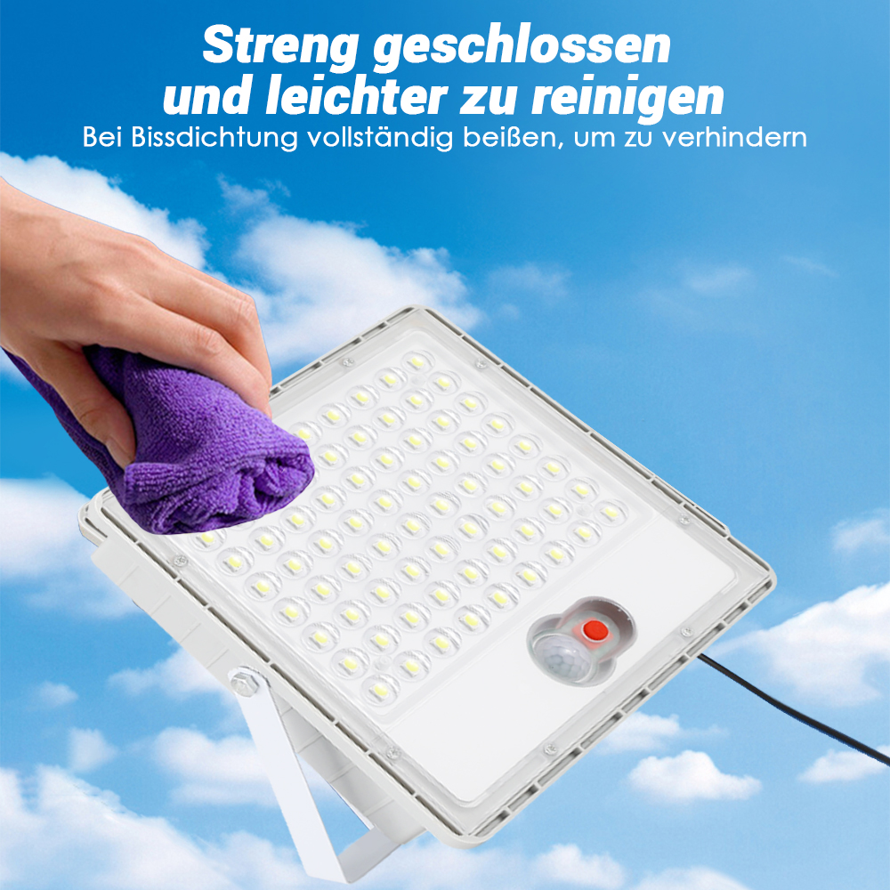 Eine Hand reinigt eine weiße LED-Lampe mit einem lila Tuch vor blauem Himmel.