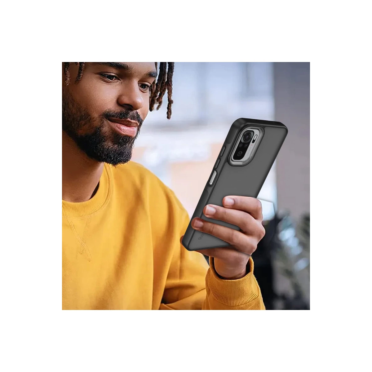 Sarı kazaklı adam kılıflı siyah akıllı telefon tutuyor.