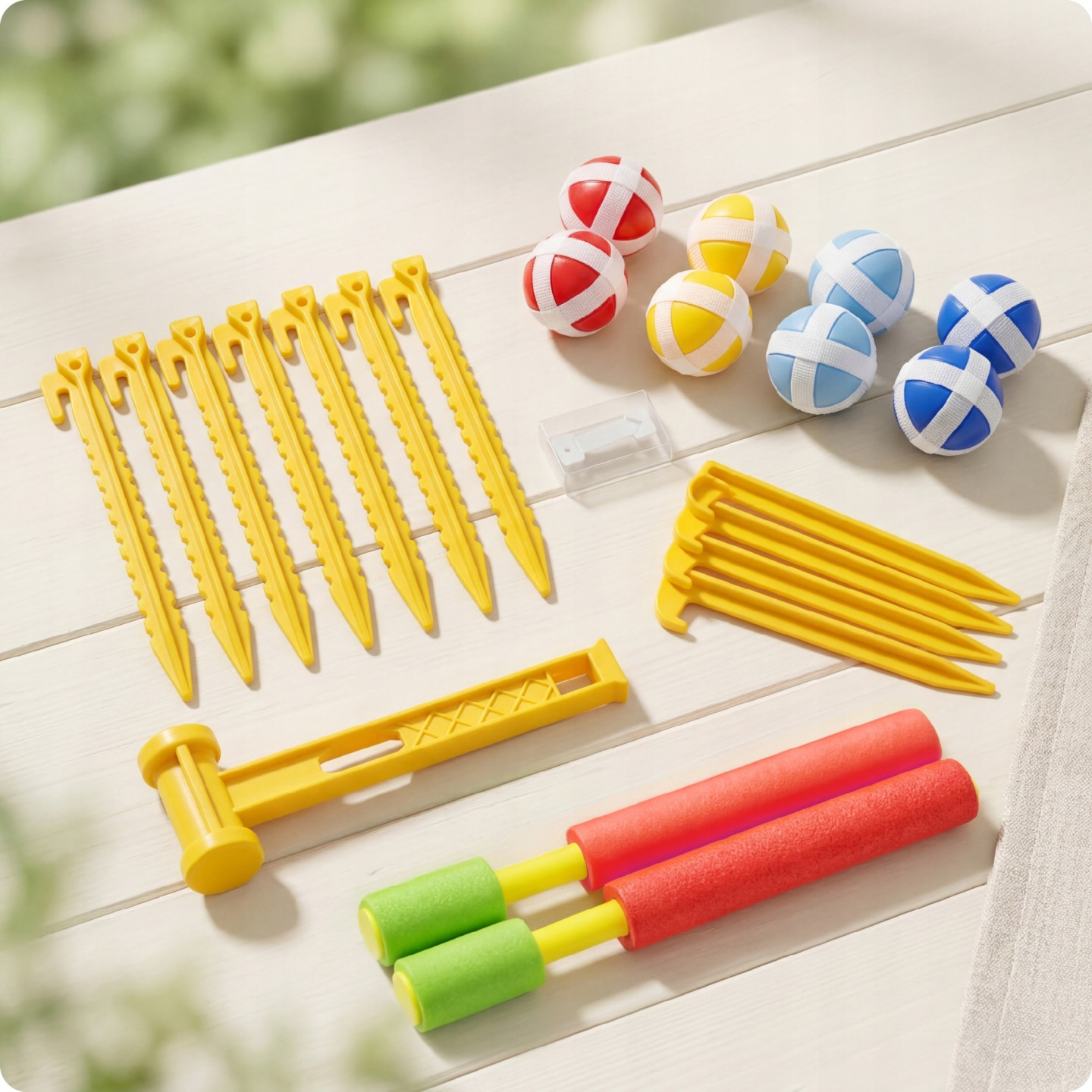 Gelbes Hammer-Spielzeug mit roten und grünen Schaumstoffgriffen, Heringen, Bällen und einem kleinen Behälter.