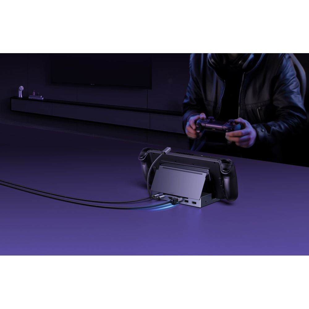 Osoba gra na kontrolerze, podczas gdy konsola przenośna jest zadokowana.