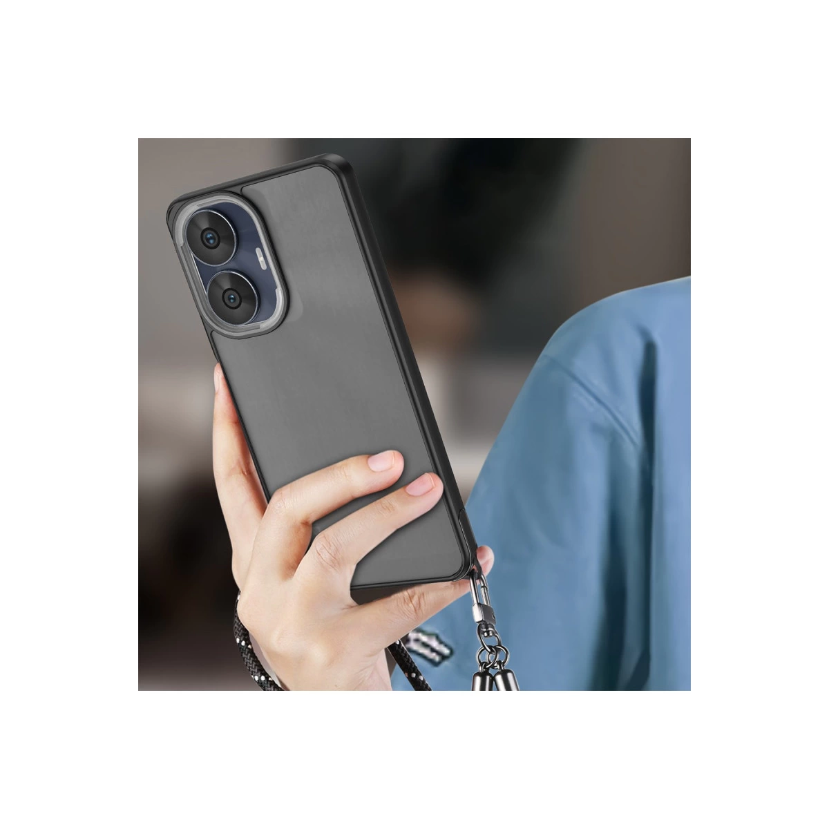 Bir el, çift lensli kameraya ve kordona sahip koyu gri bir telefon tutuyor.