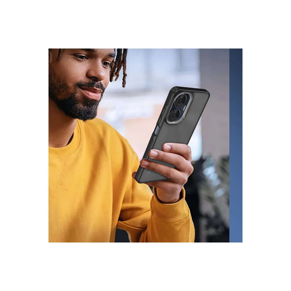 Sarı sweatshirtli bir adam, çoklu kameralı koyu renkli kılıflı bir telefon tutuyor.
