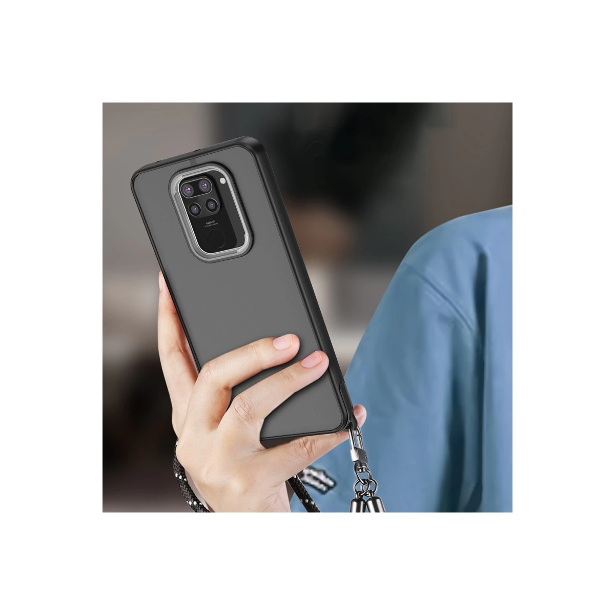 Bir kişi, dört kameralı kesimi ve bilek kayışı olan koyu gri telefon kılıfını tutuyor.
