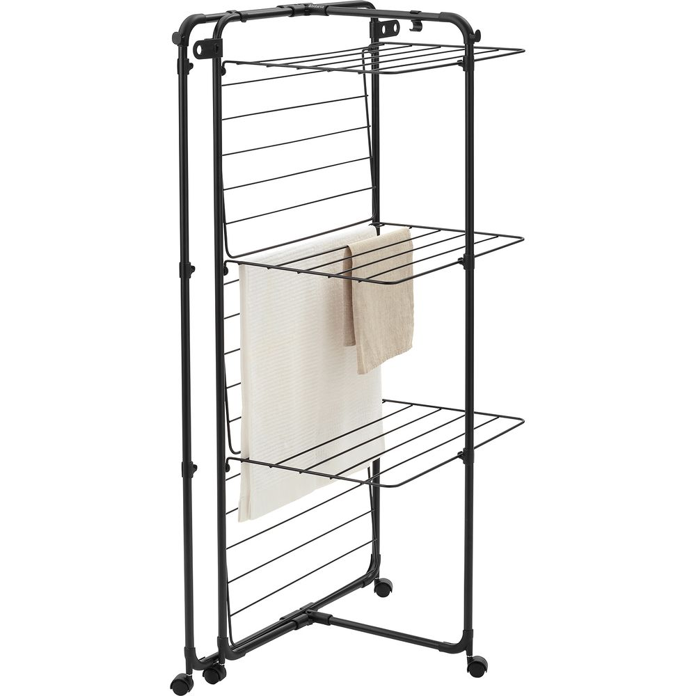 Black drying rack with wheels and three tiers, two towels hanging.