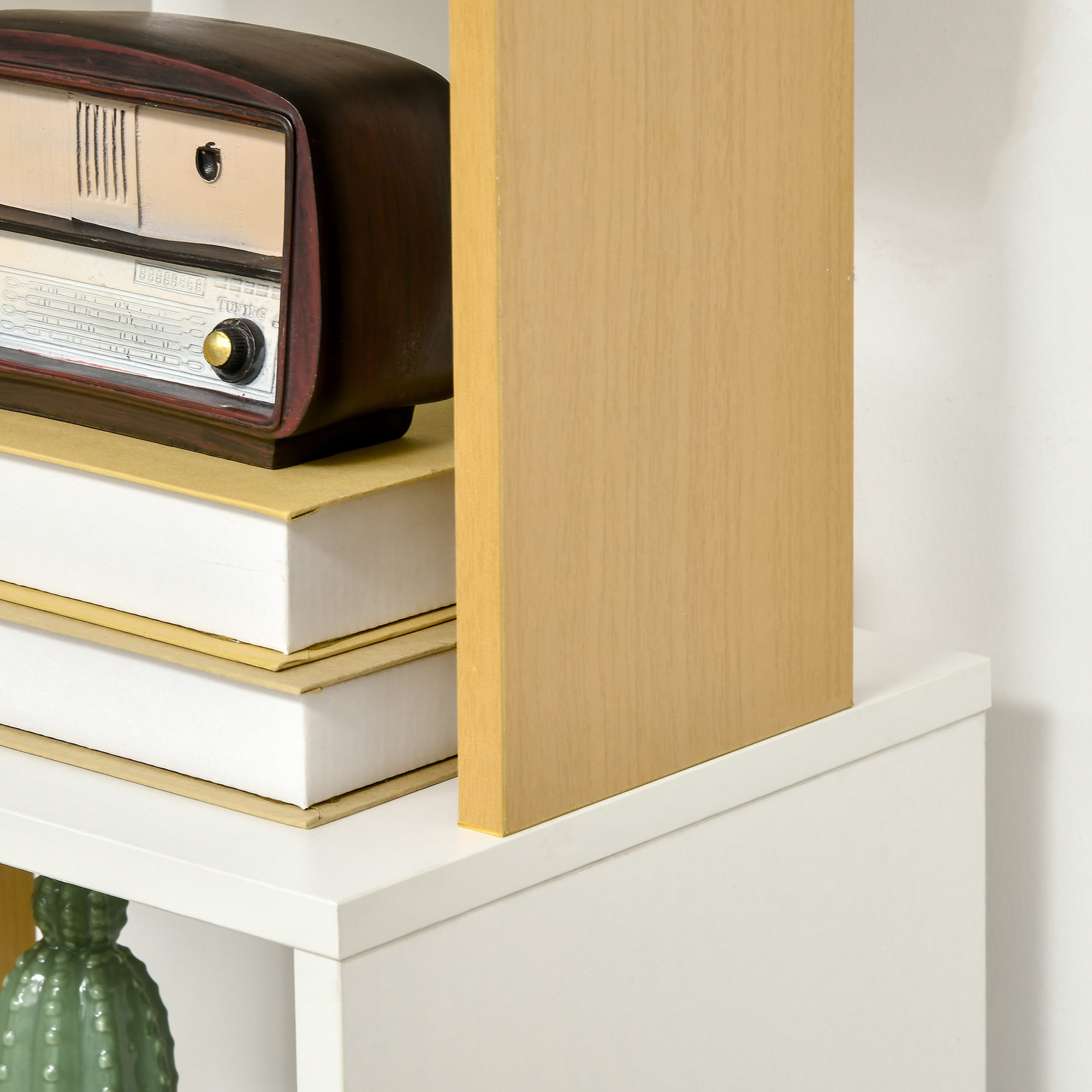 Una radio antigua sobre libros en una estantería, con un divisor de madera.