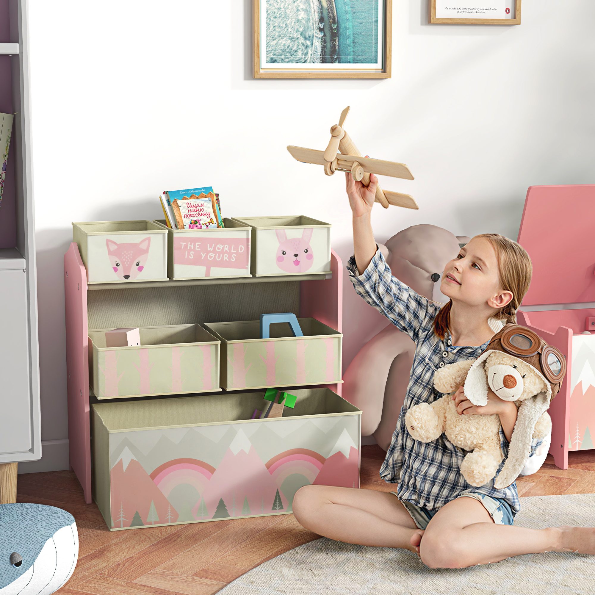 Una niña juega con un avión de madera y un peluche en una habitación infantil.