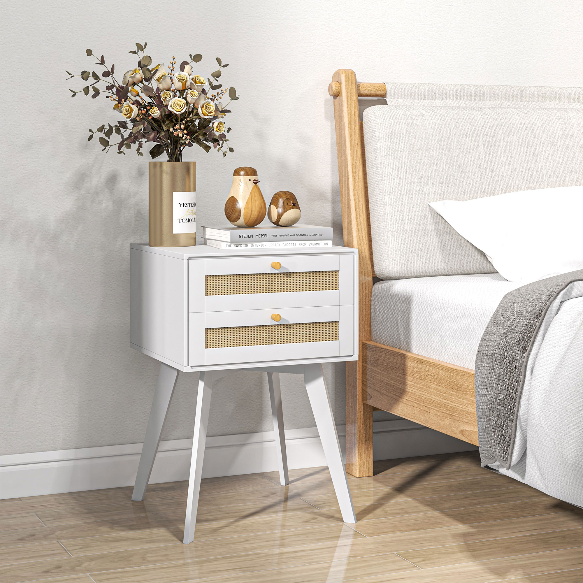 Mesita de noche blanca con ramo de flores y decoración de pájaros.