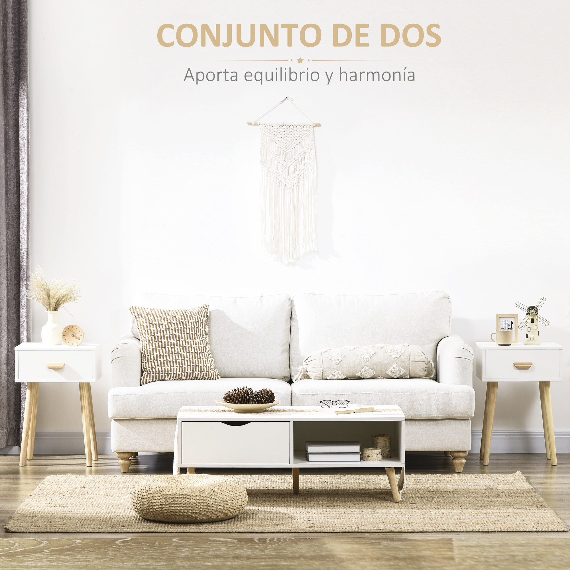 Un sofá blanco con cojines frente a una pared blanca con decoración de macramé.