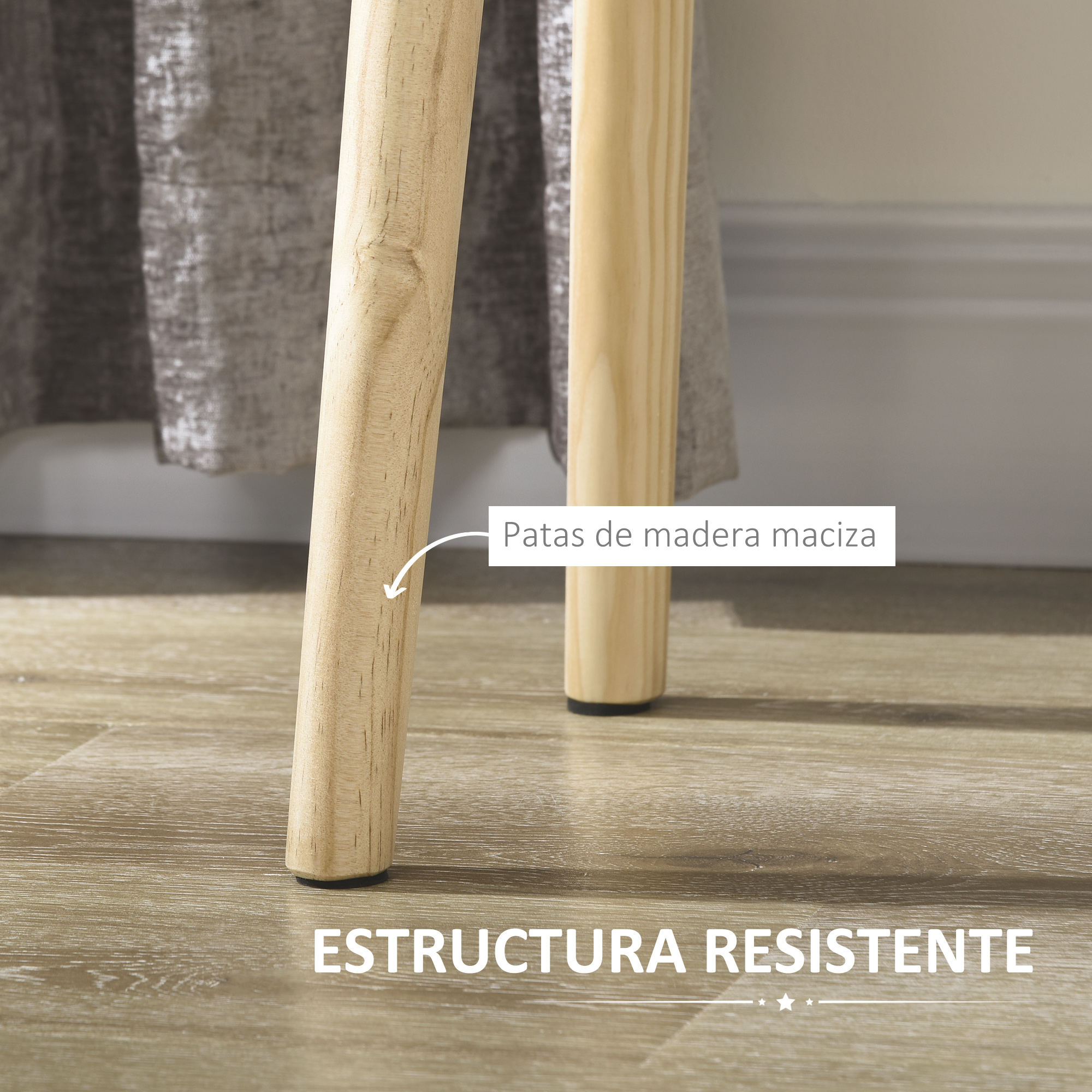 Dos patas de mesa de madera sobre suelo de madera, con tela gris al fondo.