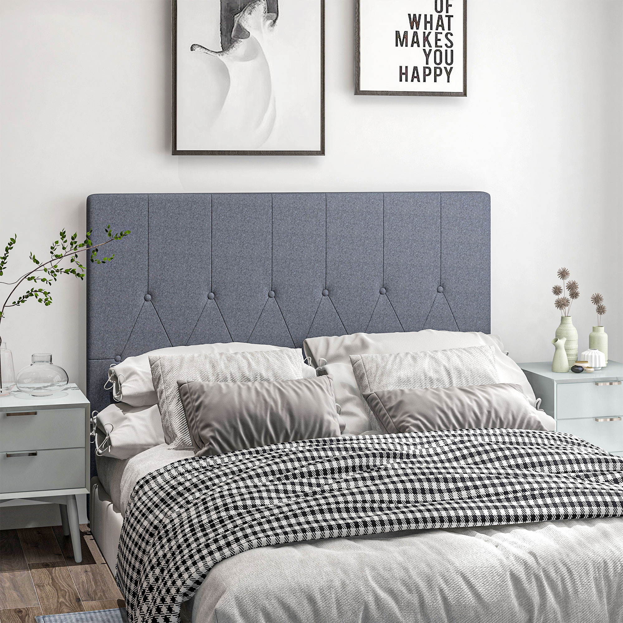 Un dormitorio con cabecero gris, manta a cuadros y mesitas de noche.
