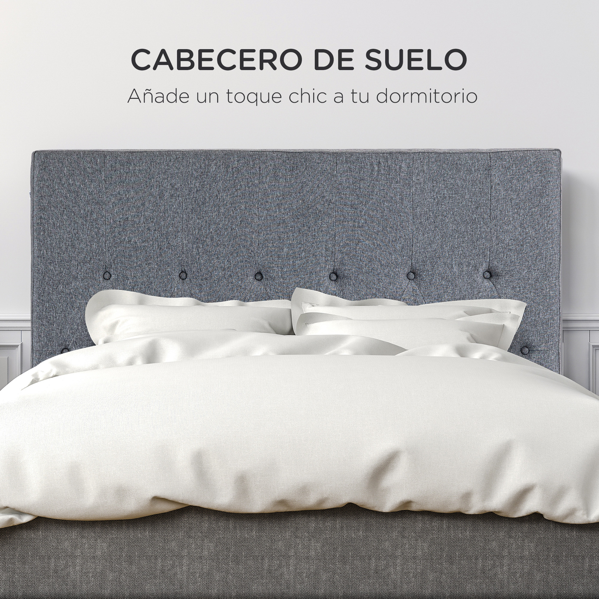 Una cama tapizada gris con almohadas blancas y cabecero capitoné.