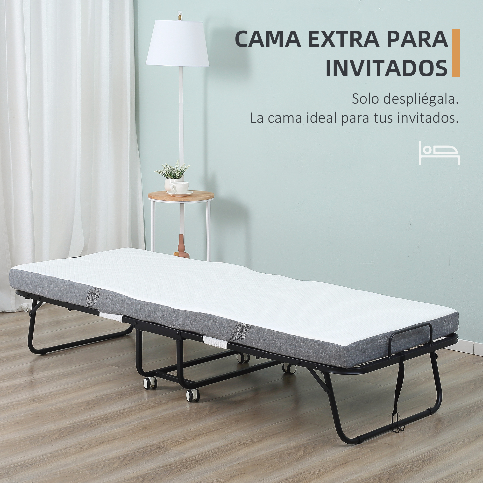Una cama plegable con colchón blanco y borde gris sobre suelo de madera.