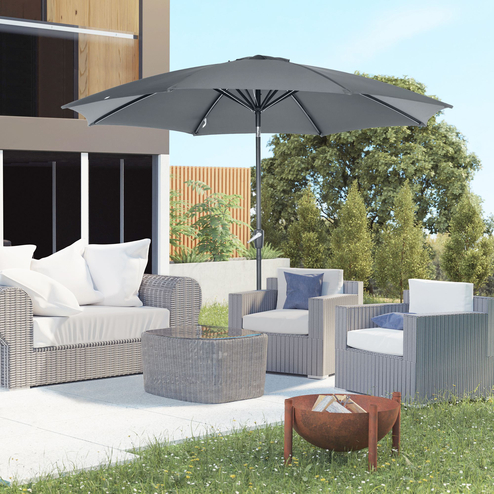 Salón exterior con muebles de mimbre, sombrilla, hoguera y árboles.