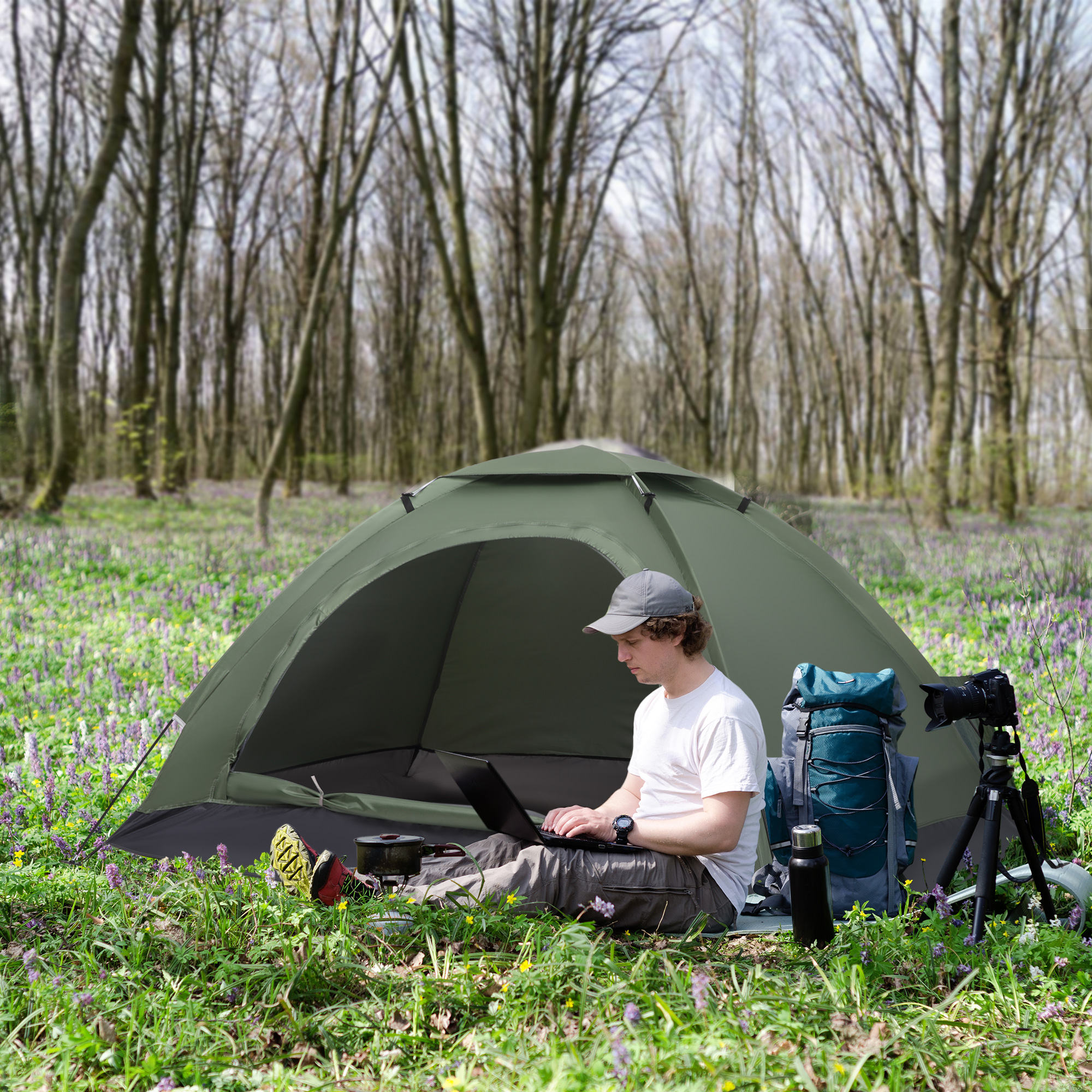 Hombre con portátil junto a tienda en bosque, mochila y cámara en trípode.